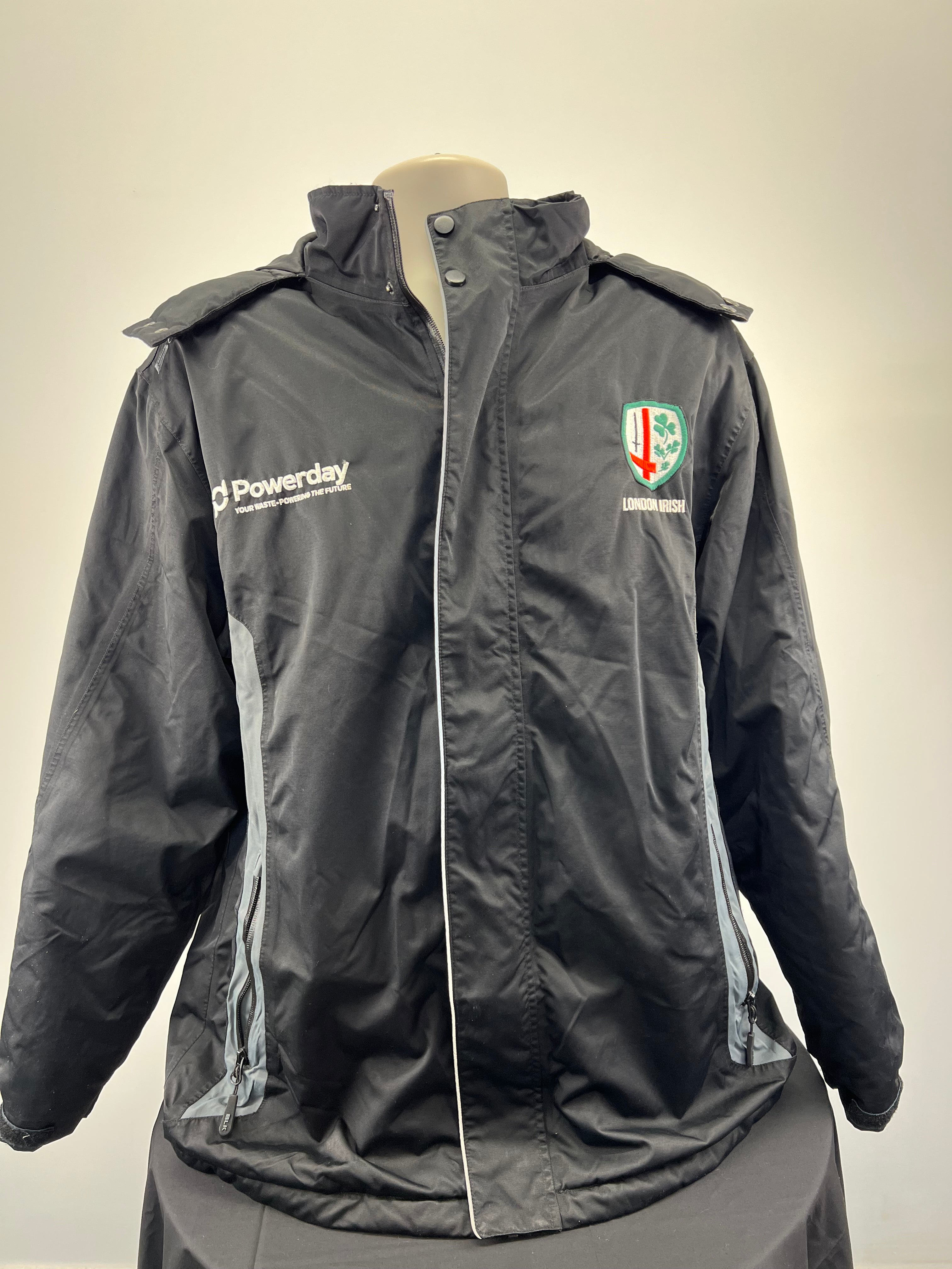 Front view of men’s London Irish black hooded jacket with logos and zip pockets