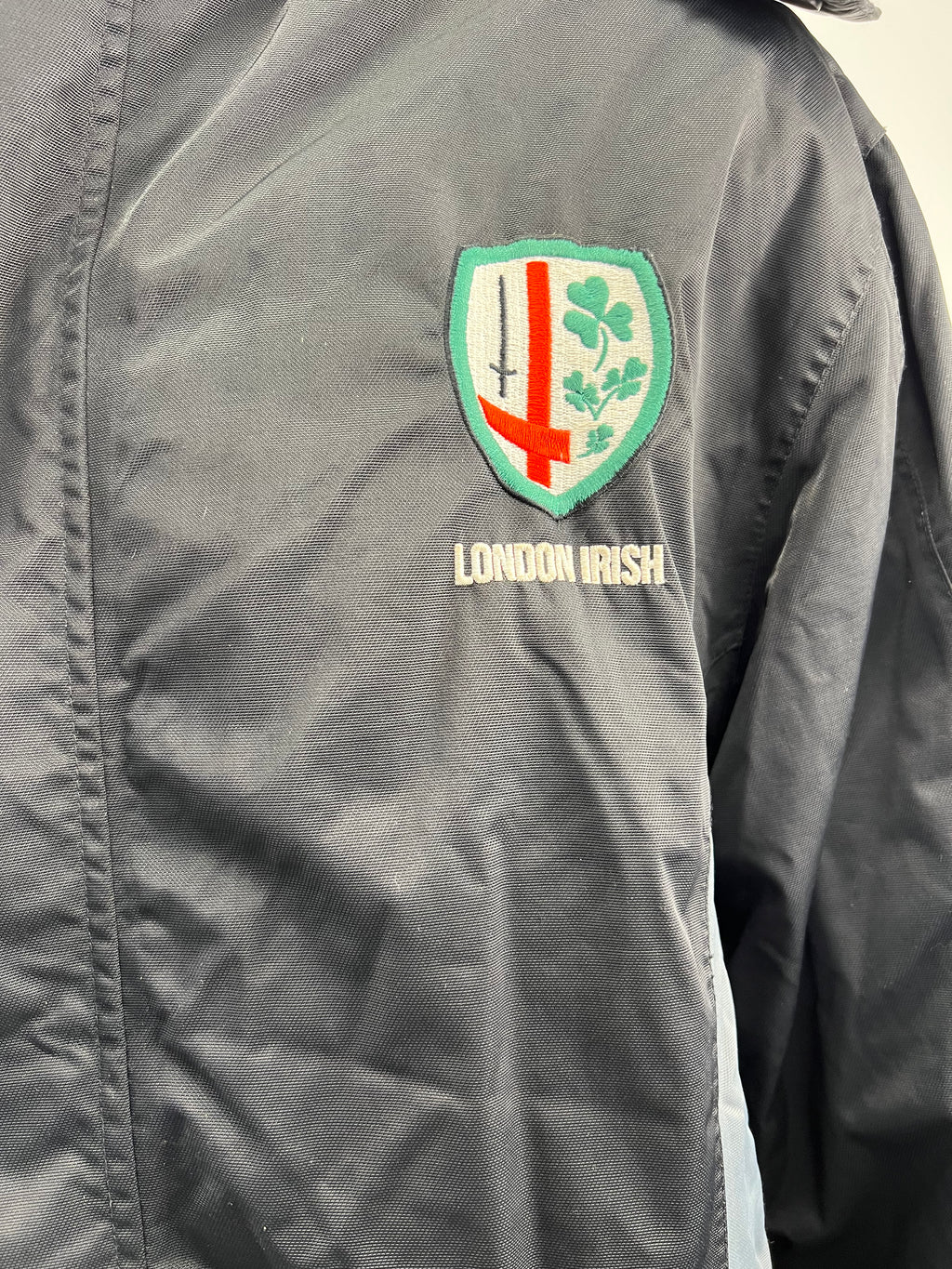 Close-up of embroidered London Irish crest on chest of black jacket