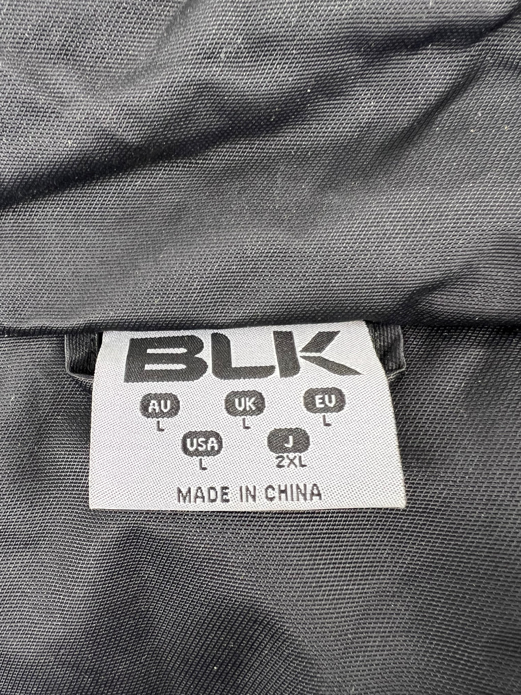 Clothing label showing BLK brand and size L for Australia, UK, USA, EU, and 2XL for Japan