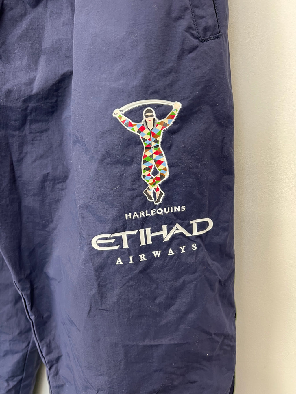 Close-up of Harlequins logo and Etihad Airways sponsor printed on right thigh of tracksuit bottoms