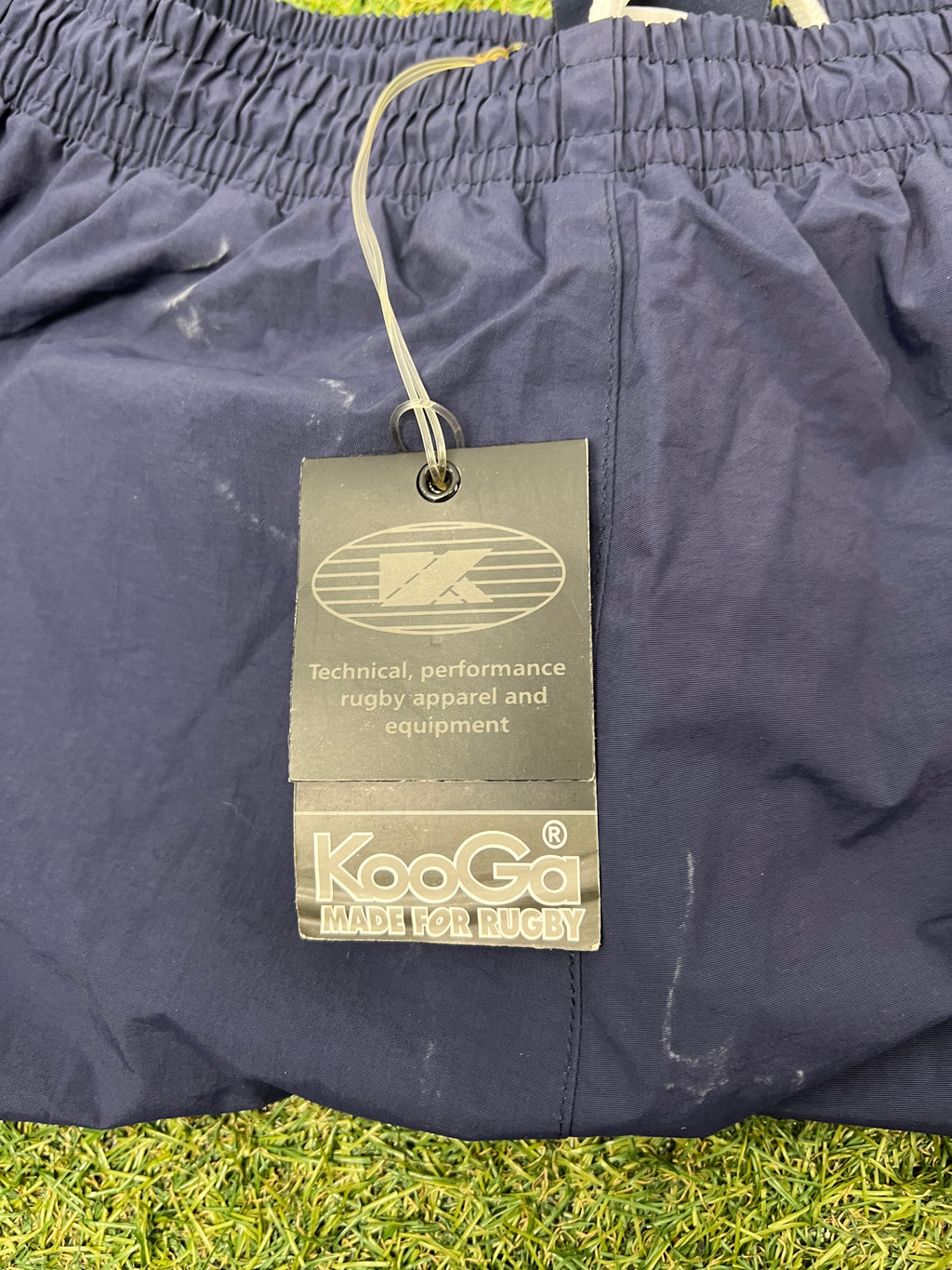 Close-up of Kooga brand tag attached to the tracksuit bottoms highlighting rugby performance apparel