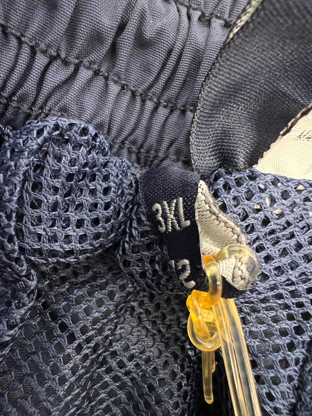 Close-up of elastic waistband with size label 3XL inside tracksuit bottoms