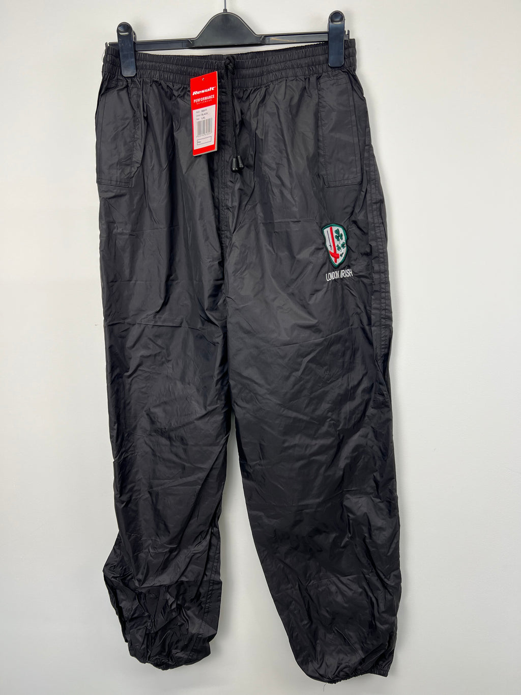 Men’s London Irish black waterproof rugby trousers front view hanging on clip hanger