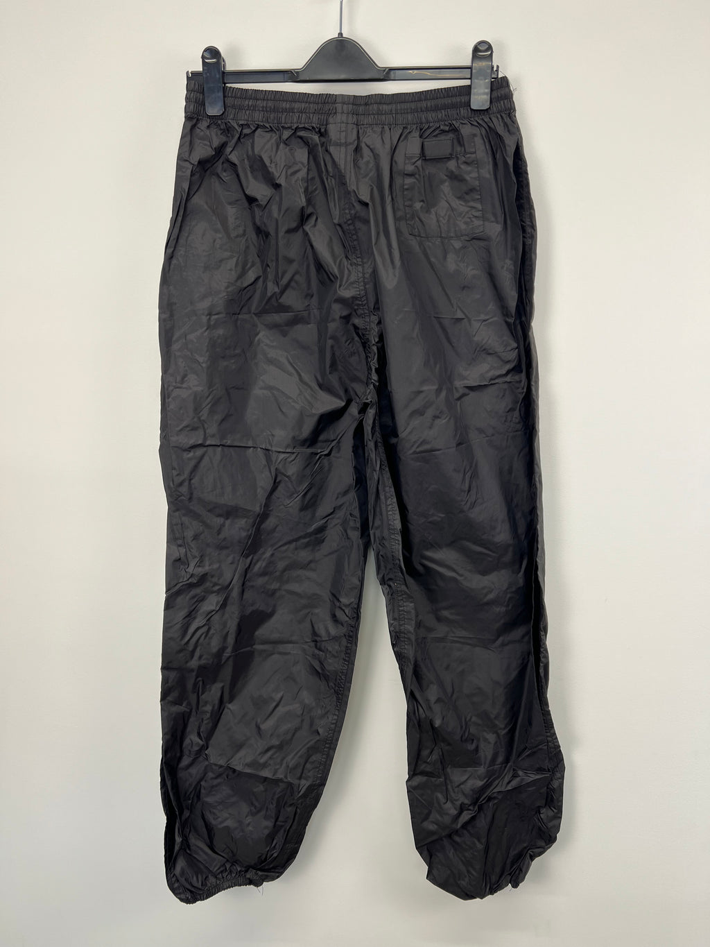 Back view of men’s London Irish black waterproof rugby trousers with elastic waistband and ankle cuffs