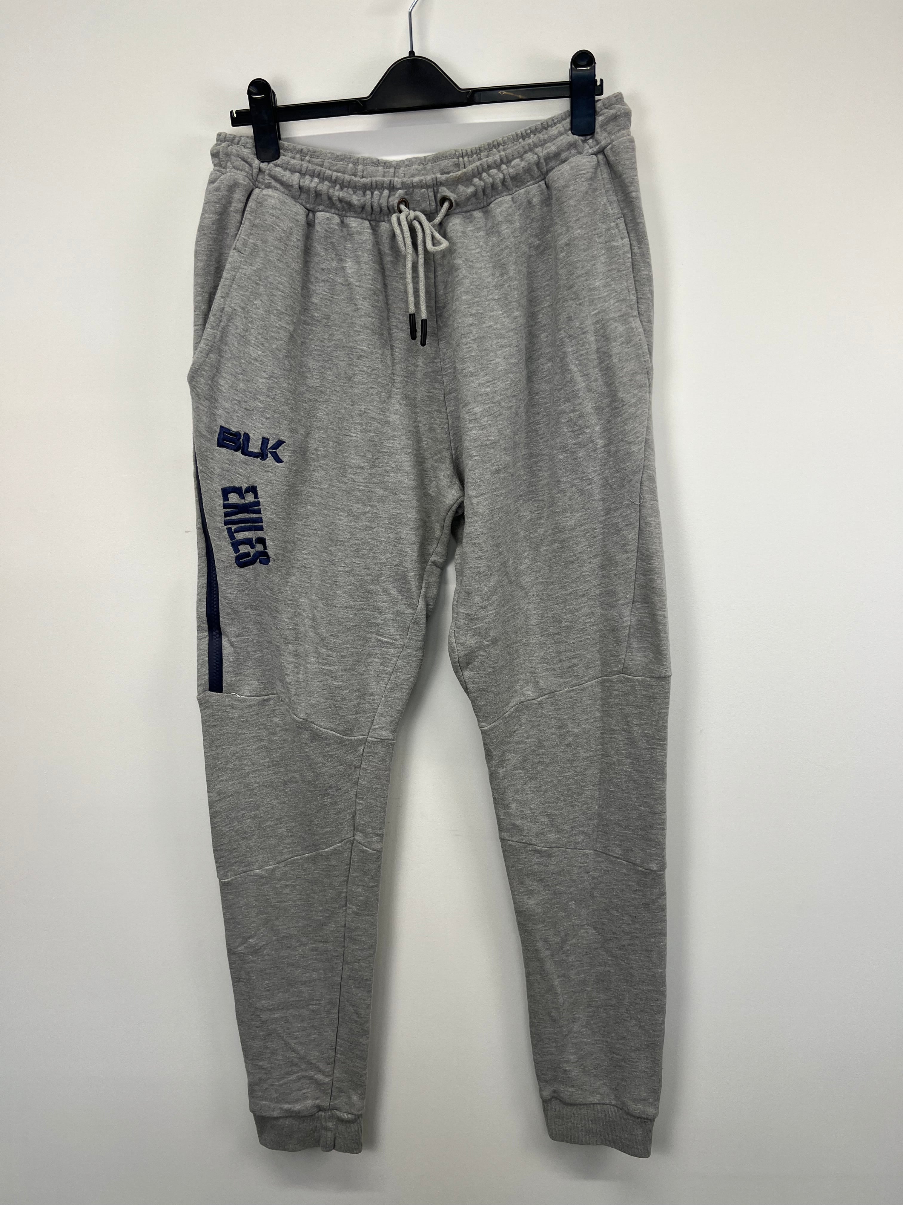 Front view of Men’s BLK Exiles grey tracksuit trousers hanging on black hanger