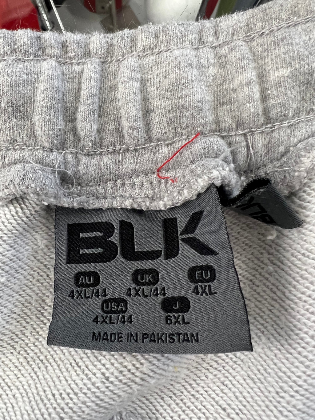 Close-up of size label inside waistband showing 4XL size and brand BLK