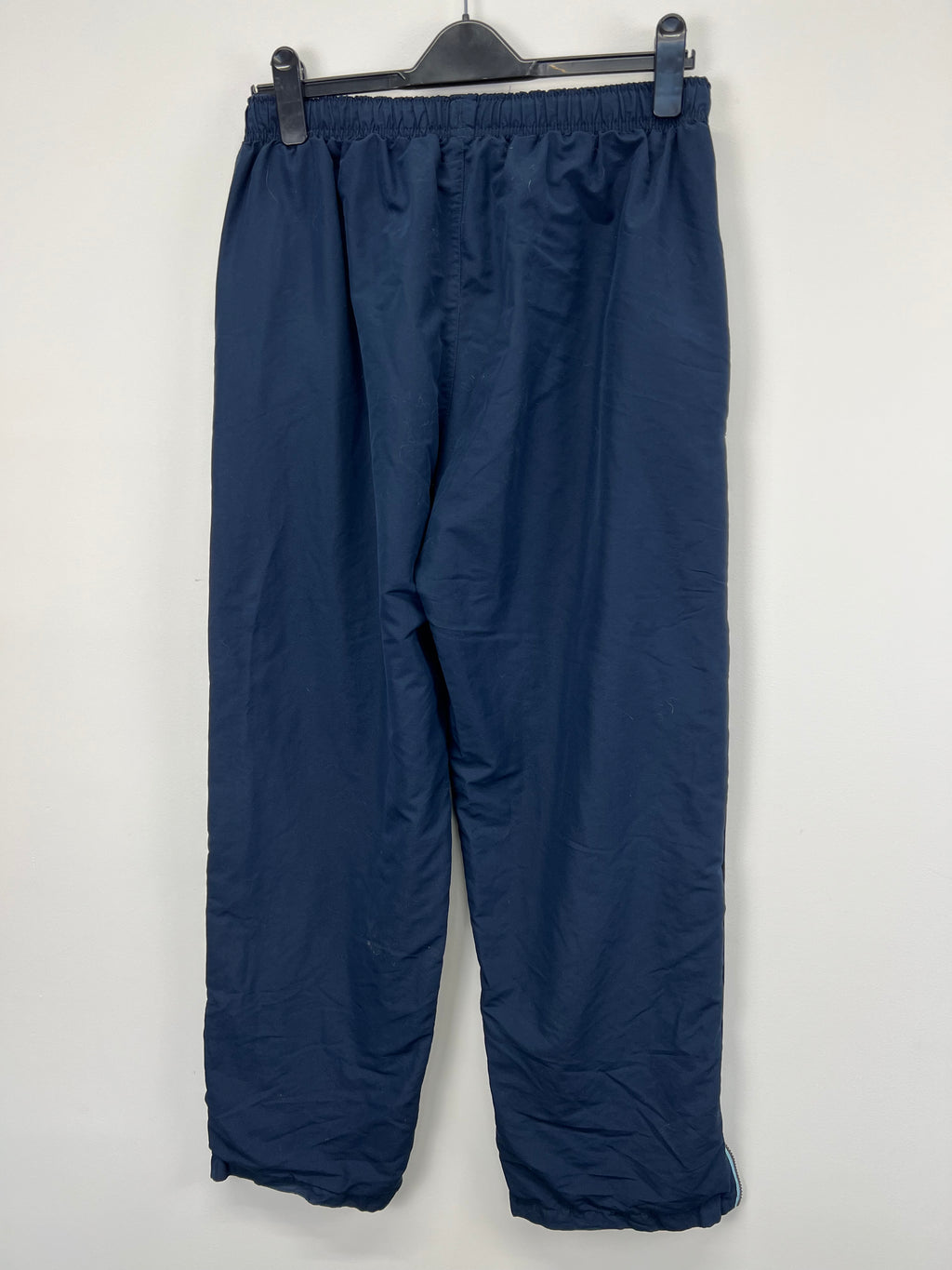 Back view of men's navy tracksuit trousers showing plain fabric and elasticated waist