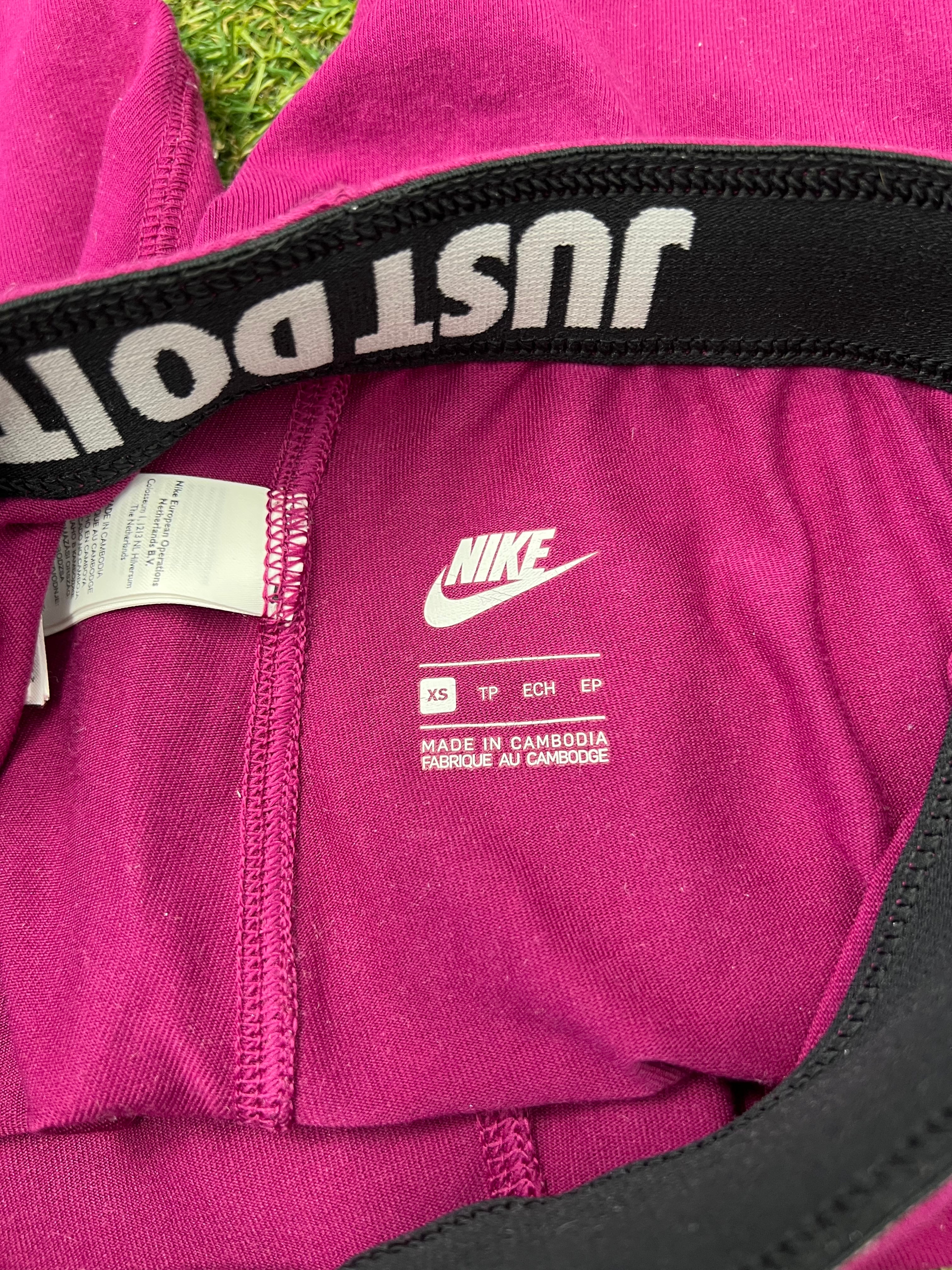 Close-up of Nike leggings inside waistband showing size XS, Made in Cambodia label and Just Do It elastic waistband