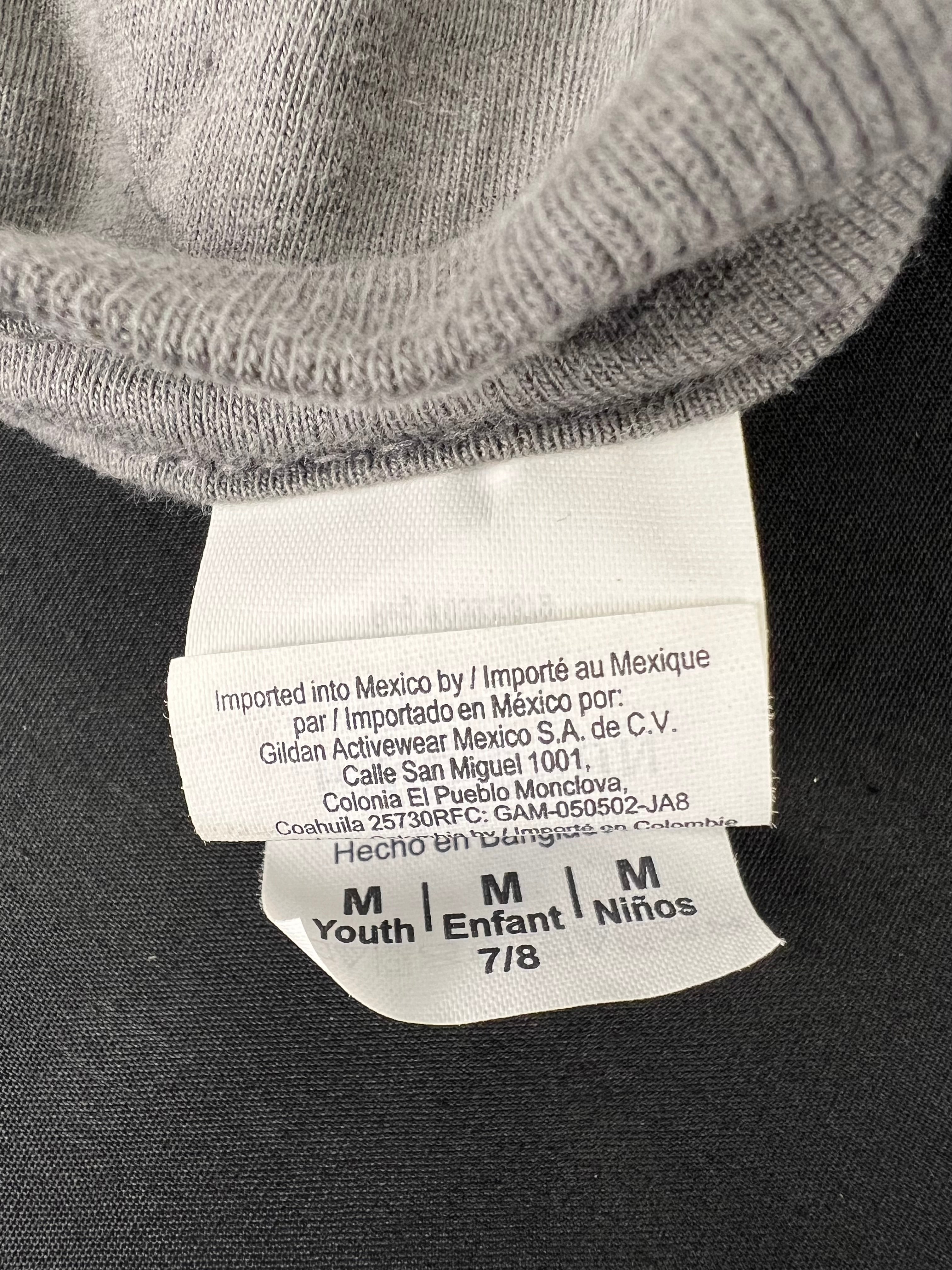 Close-up of sizing and manufacturing label inside grey kids t-shirt, indicating size 7/8