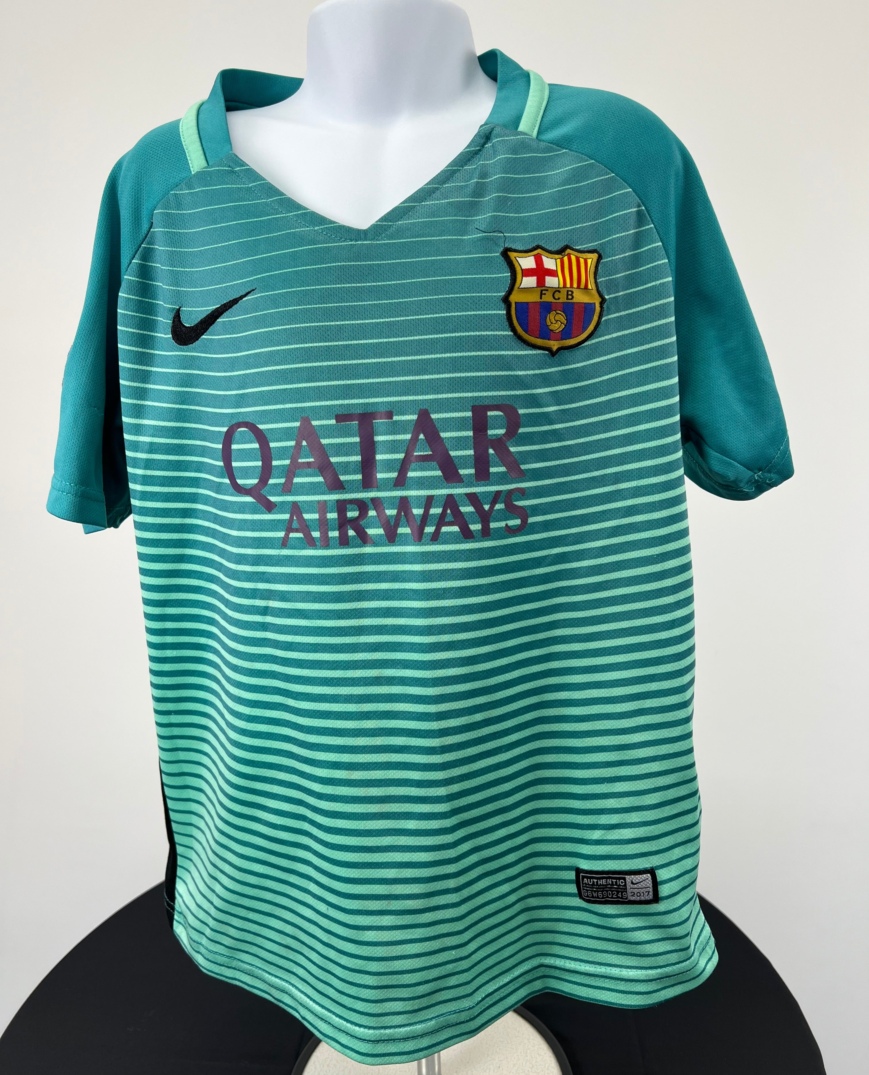 Front view of teal Kids FC Barcelona football shirt with horizontal stripes and Qatar Airways logo