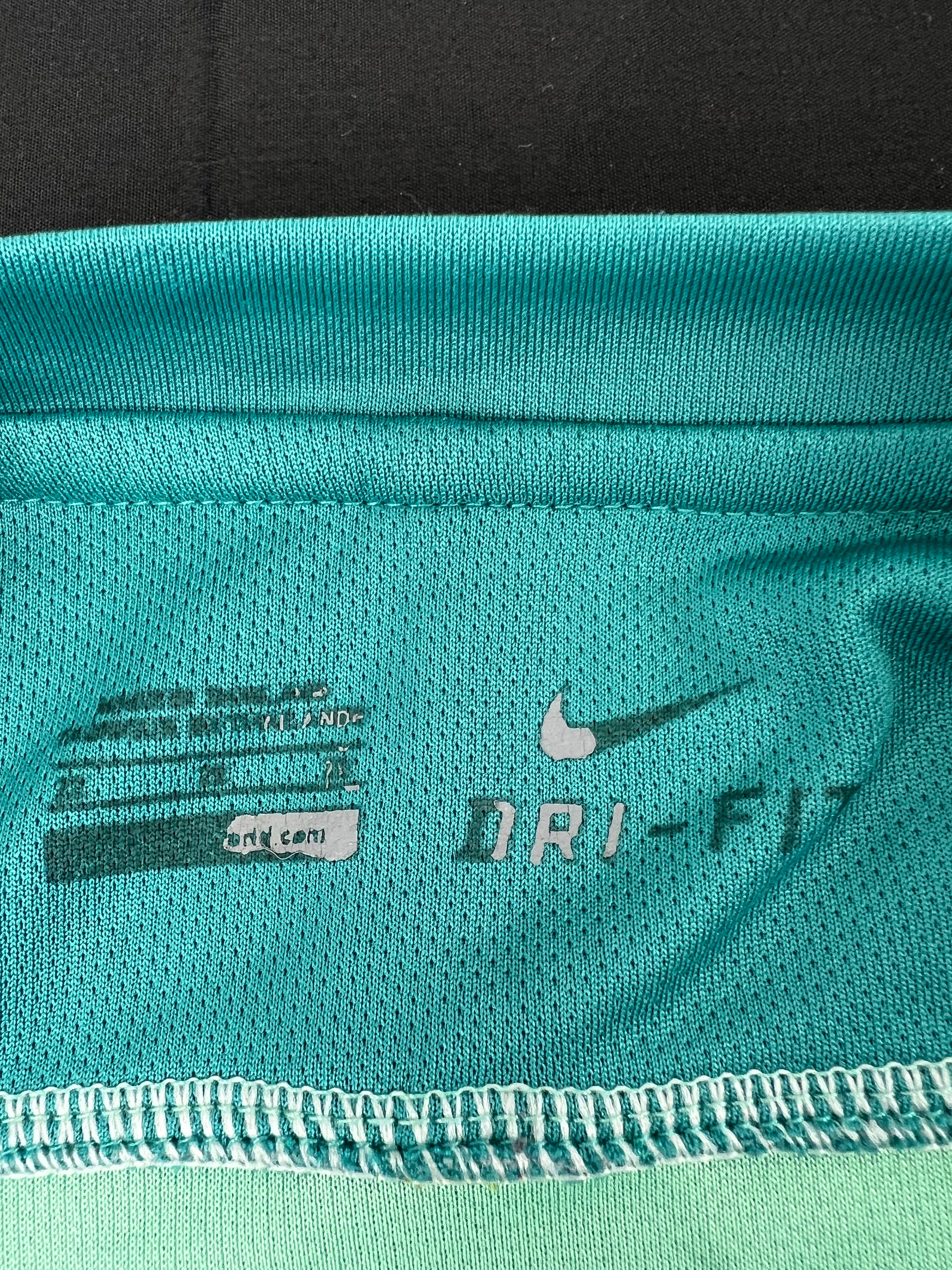 Close-up image showing Nike Dri-FIT branding and size tag inside the football shirt
