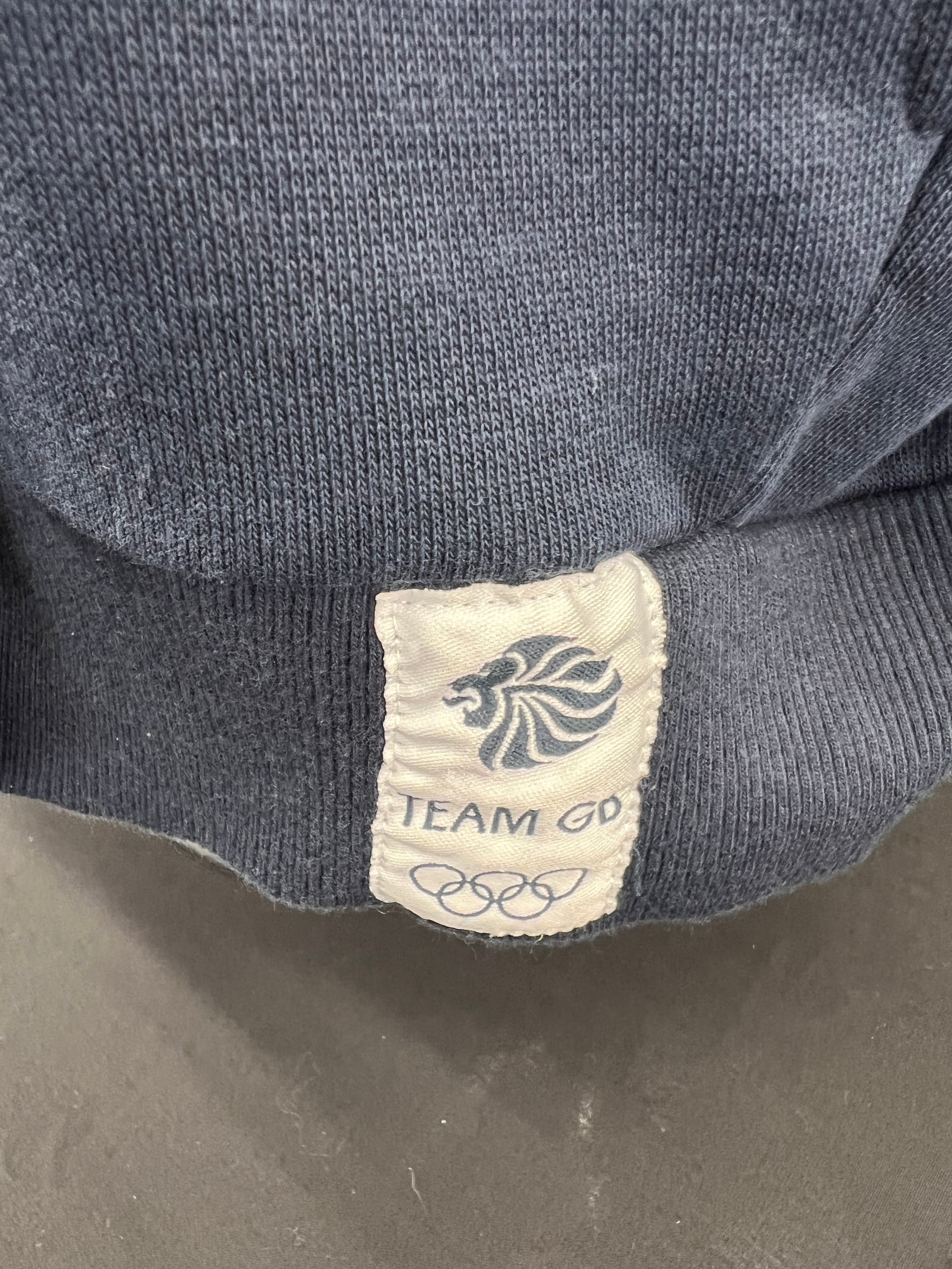 Close-up of Team GB and Olympic rings tag on navy hoodie hem