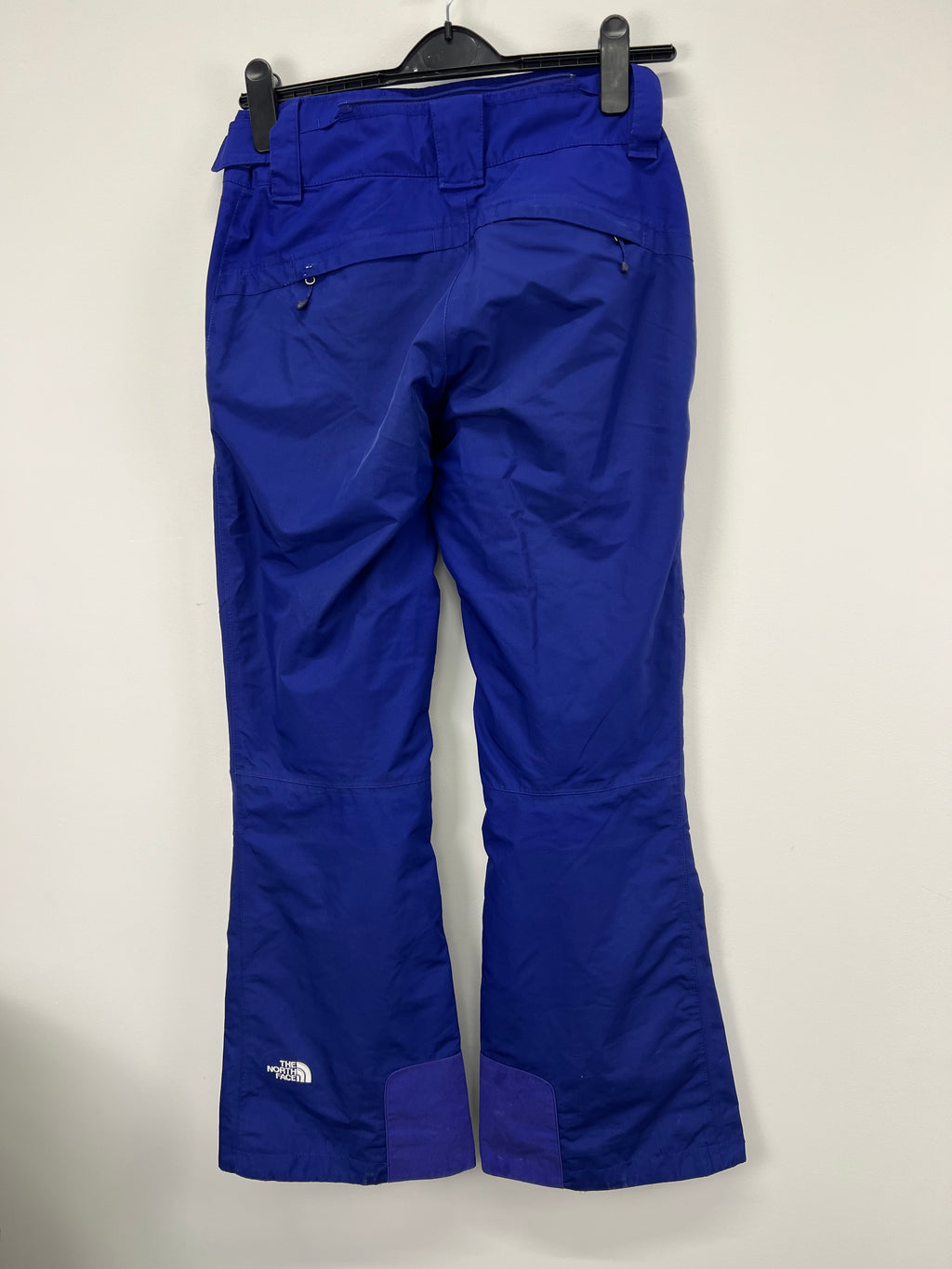 Rear view of blue The North Face women's ski trousers size XS showing pockets and reinforced cuffs