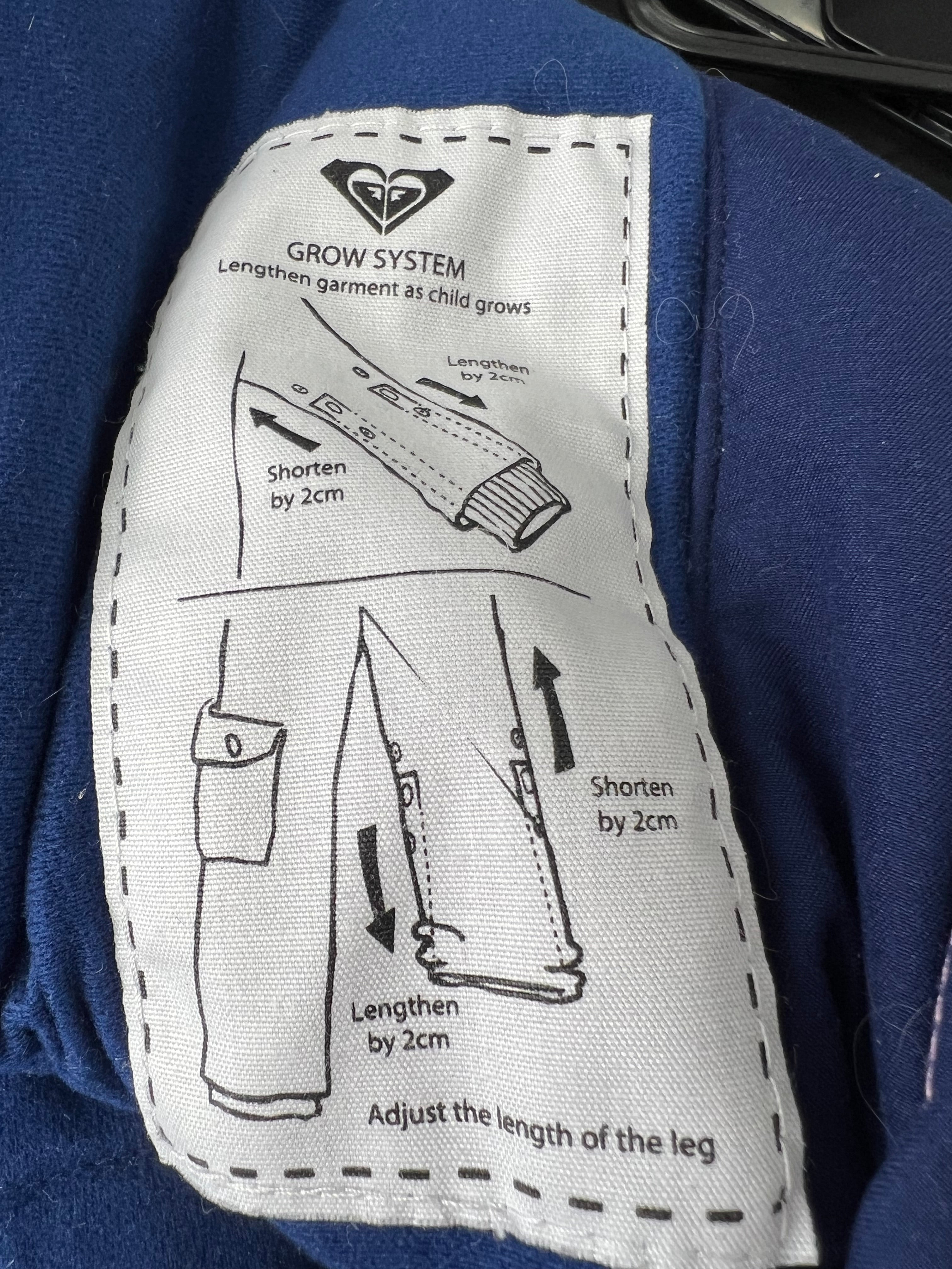 Illustration label explaining Grow System for adjustable sleeve and leg length of the snow suit