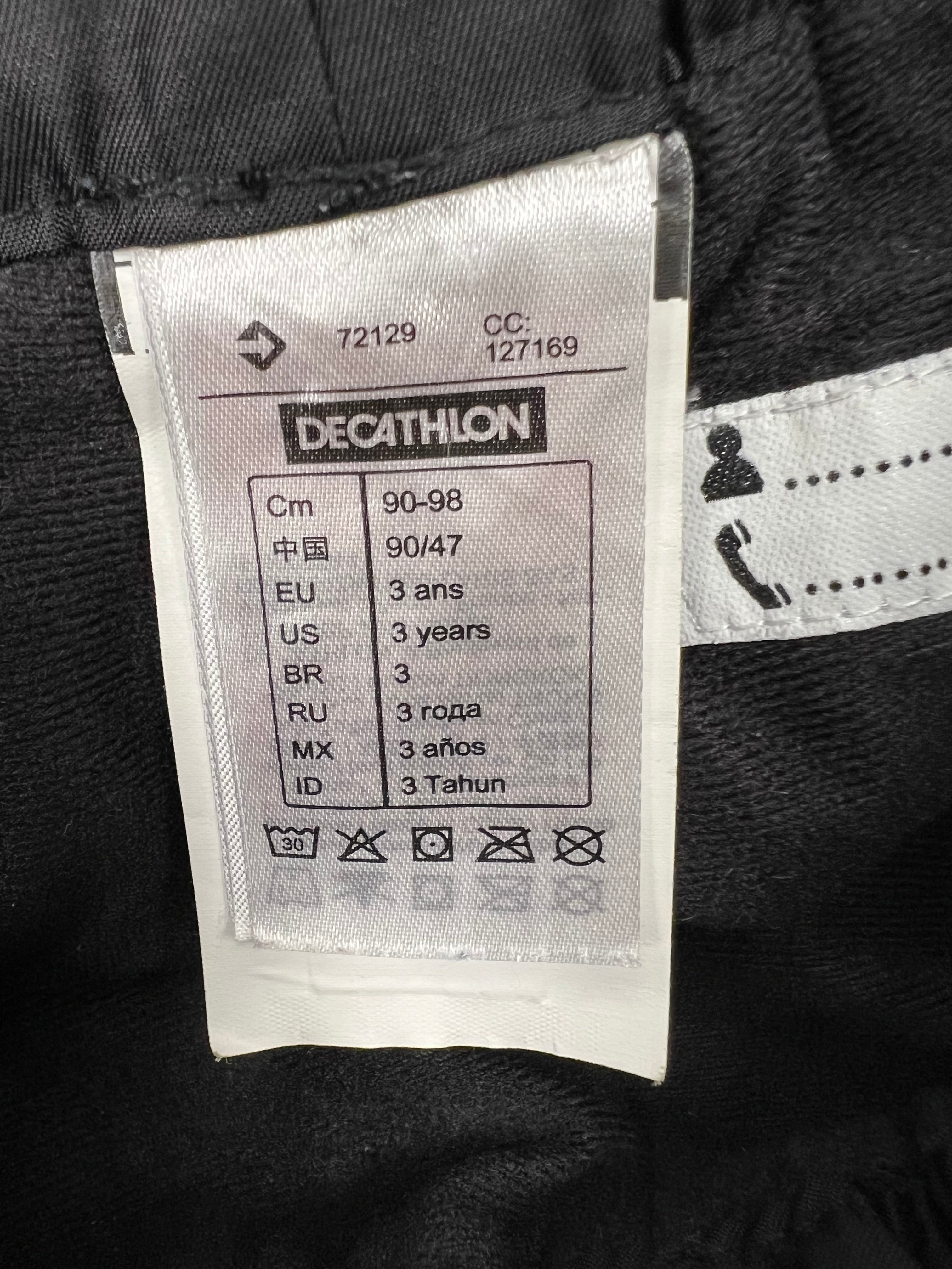 Close-up of Decathlon sizing and care label inside kids ski trousers showing size 3 years