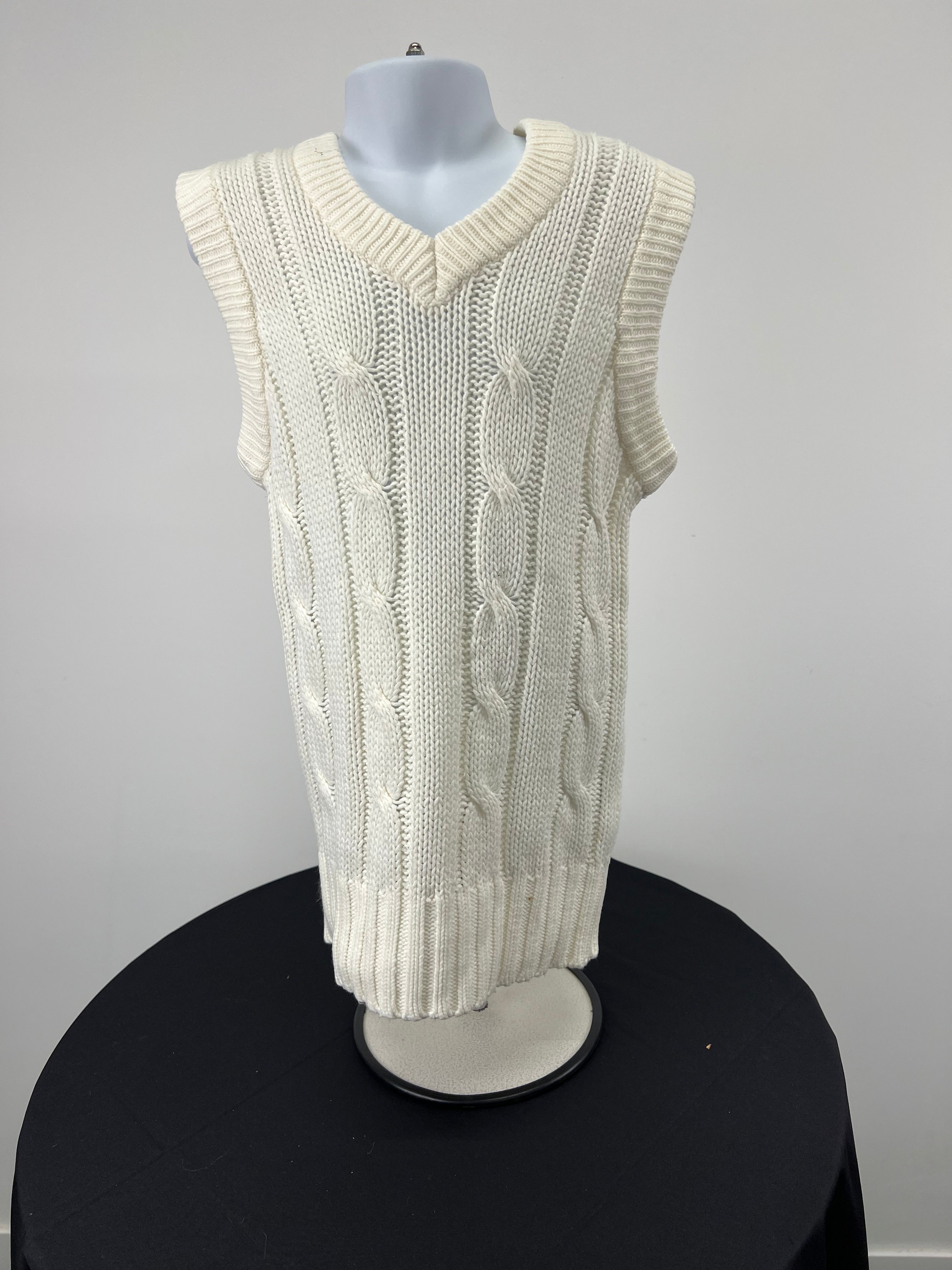 Front view of kids cream coloured cable knit sleeveless Slazenger cricket pullover