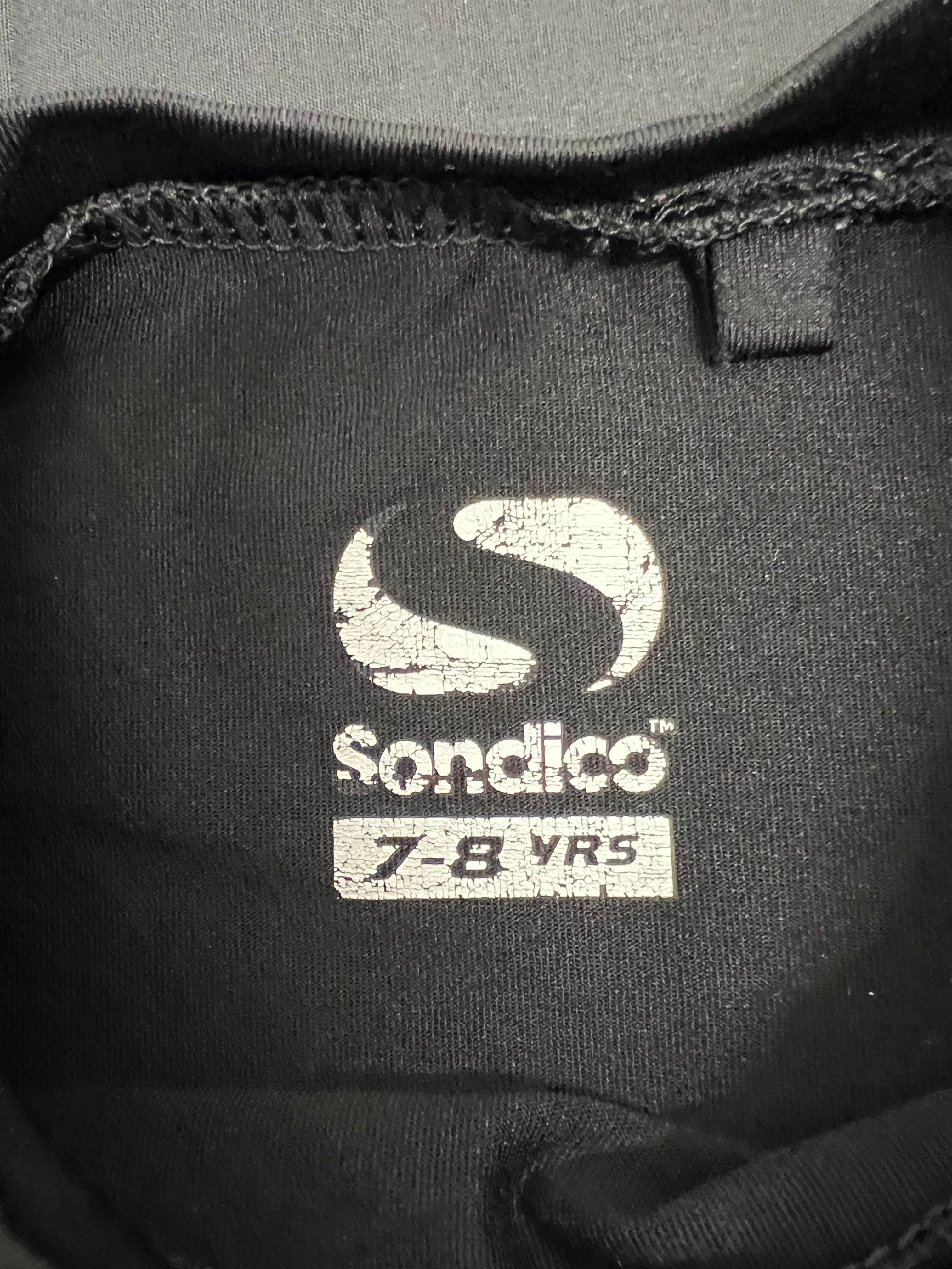 Close-up of inside neck label on black Sondico base layer top marking size 7-8 years