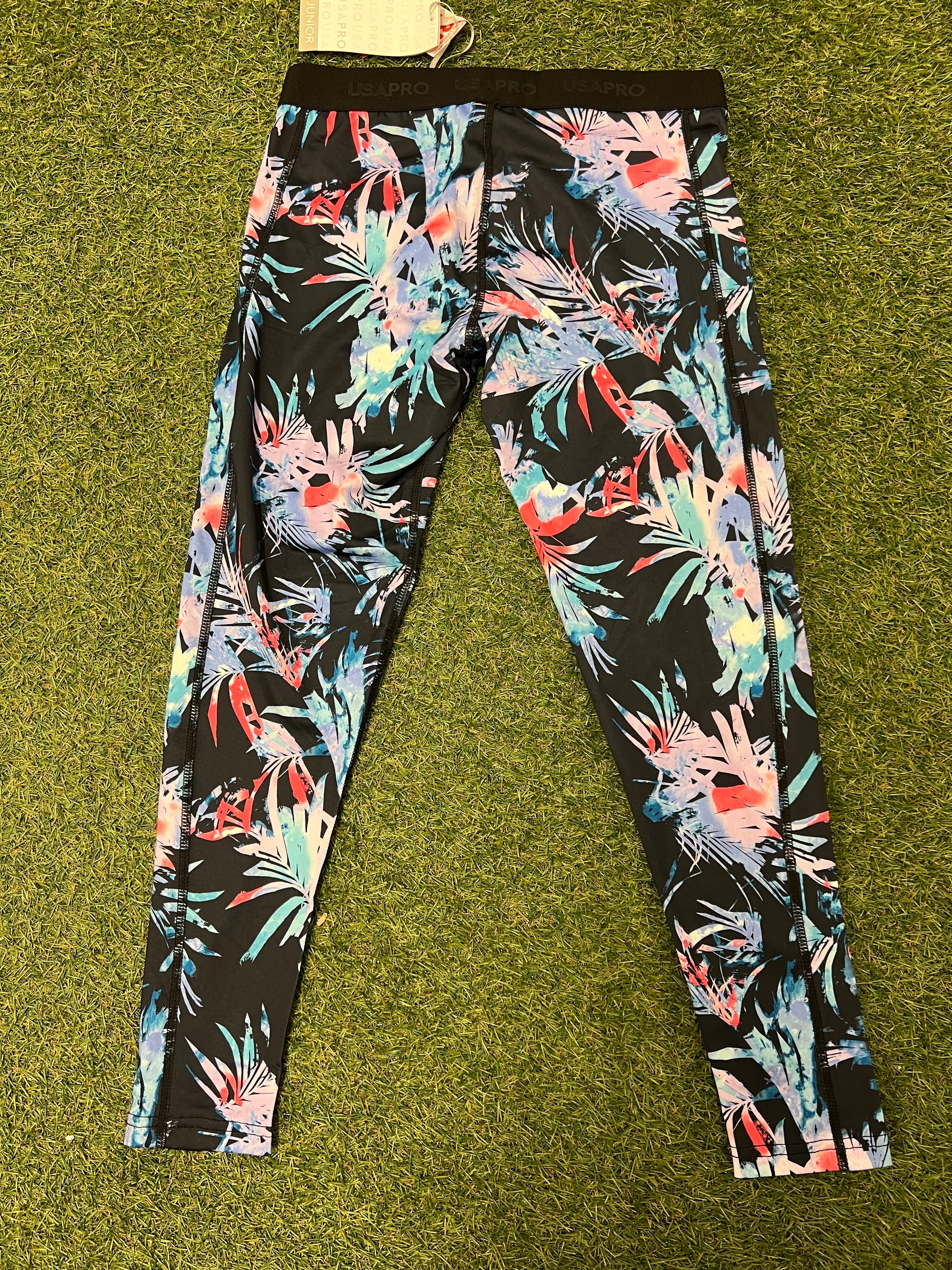 Front view of USA Pro teenagers leggings with multi-colour tropical pattern on black fabric