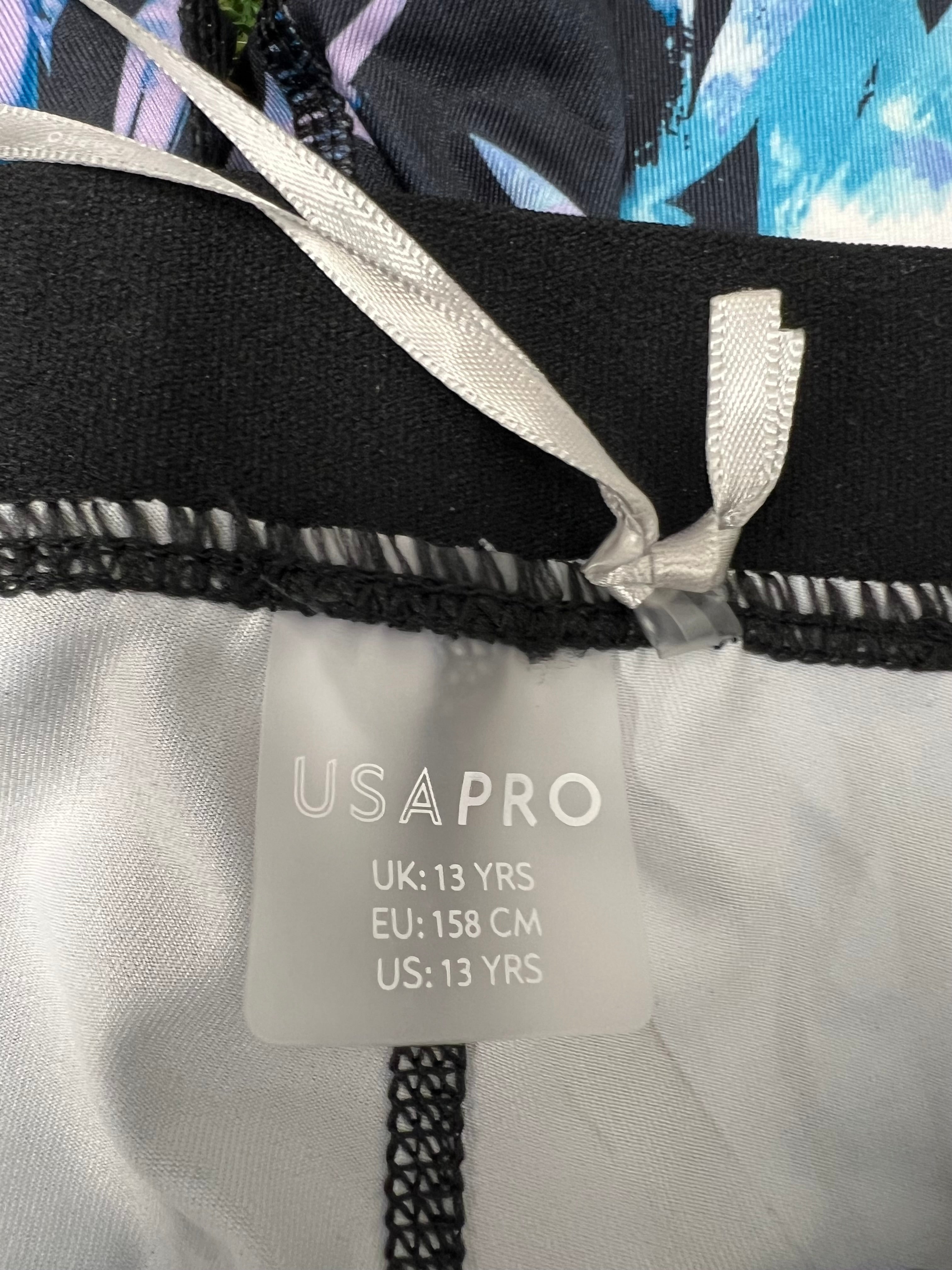 Close-up of USA Pro leggings label inside waistband indicating size age 13