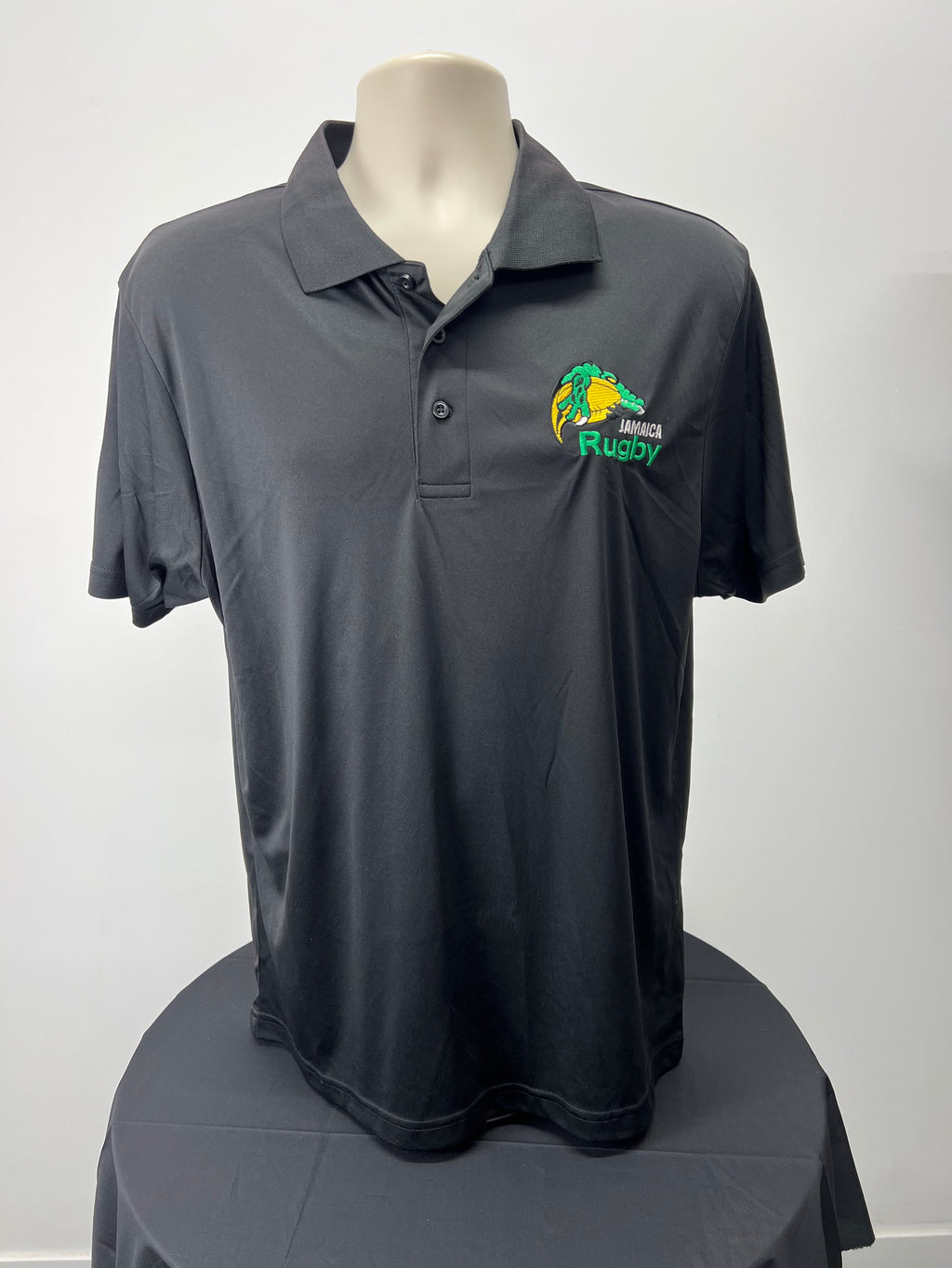 Front view of black Jamaica rugby polo shirt with embroidered logo on chest