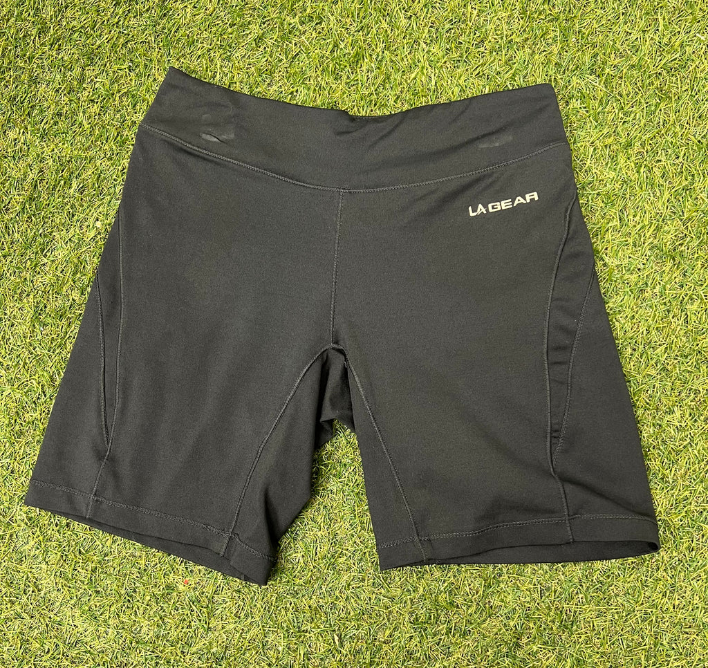 Front view of black women’s LA Gear cycling shorts laid flat on grass