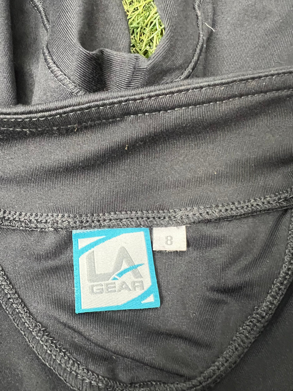Close-up of LA Gear brand label and size 8 tag inside black cycling shorts