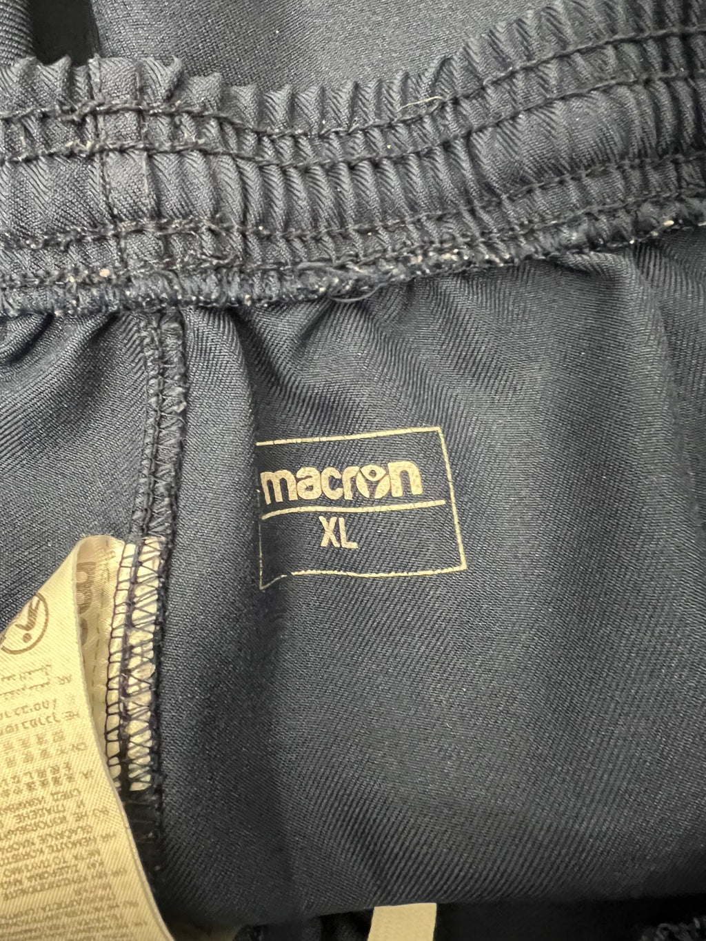 Close-up of inside waistband label showing Macron branding and XL size tag