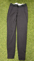 Front view of black Reebok x Les Mills Speedwick women's leggings laid flat on grass