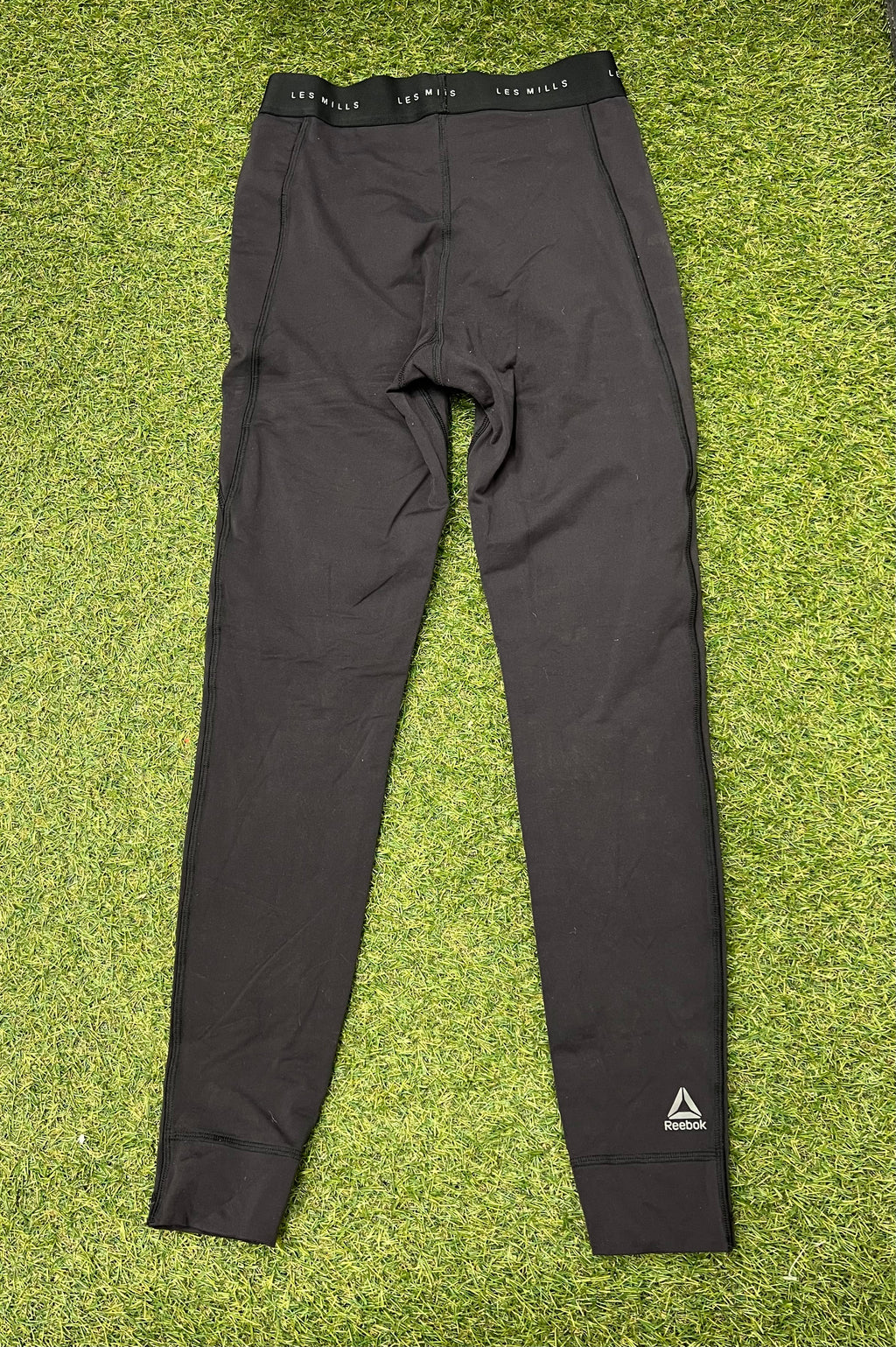 Rear view of black Reebok x Les Mills Speedwick women's leggings showing branding on waistband and logo on leg