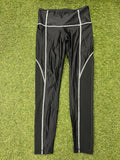 Front view of black Women’s Reebok Speedwick leggings with white stitching laid flat on grass
