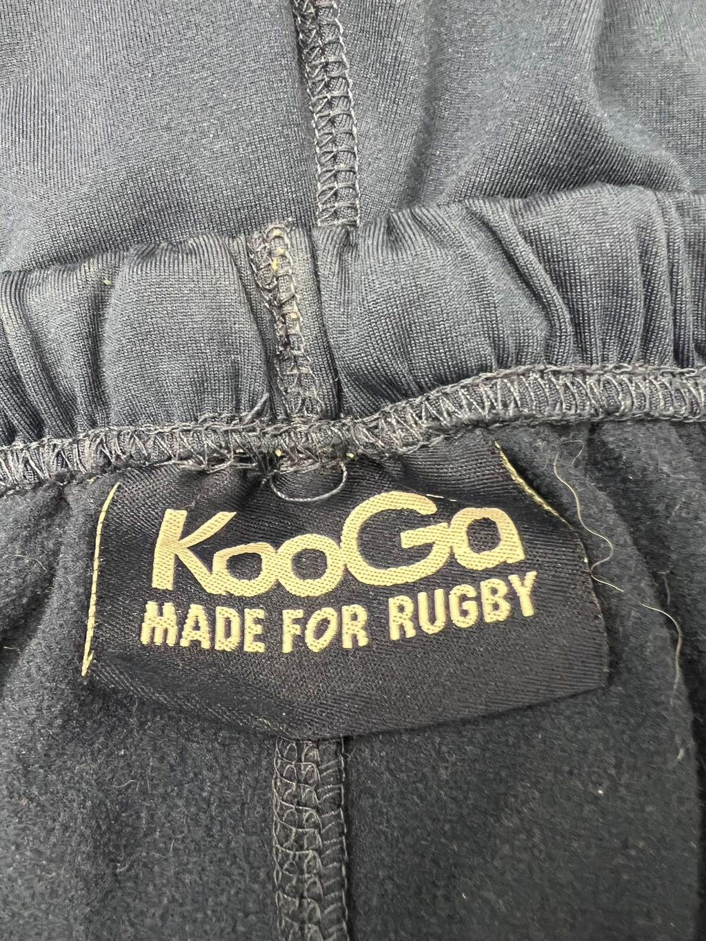 Close-up of KooGa label inside navy fleece lined rugby shorts showing fleece texture