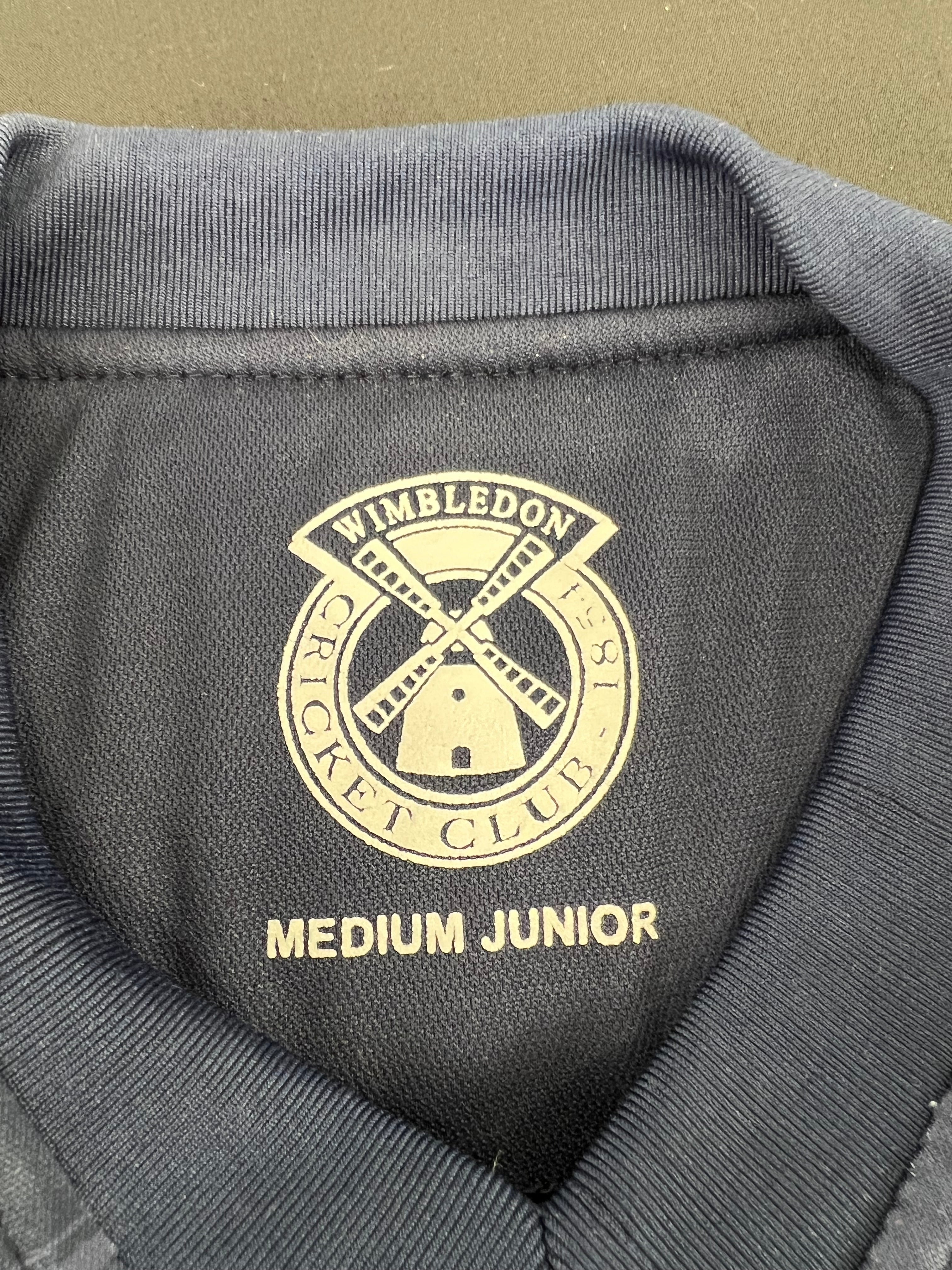 Close-up view of Wimbledon Cricket Club crest and medium junior size label inside pullover