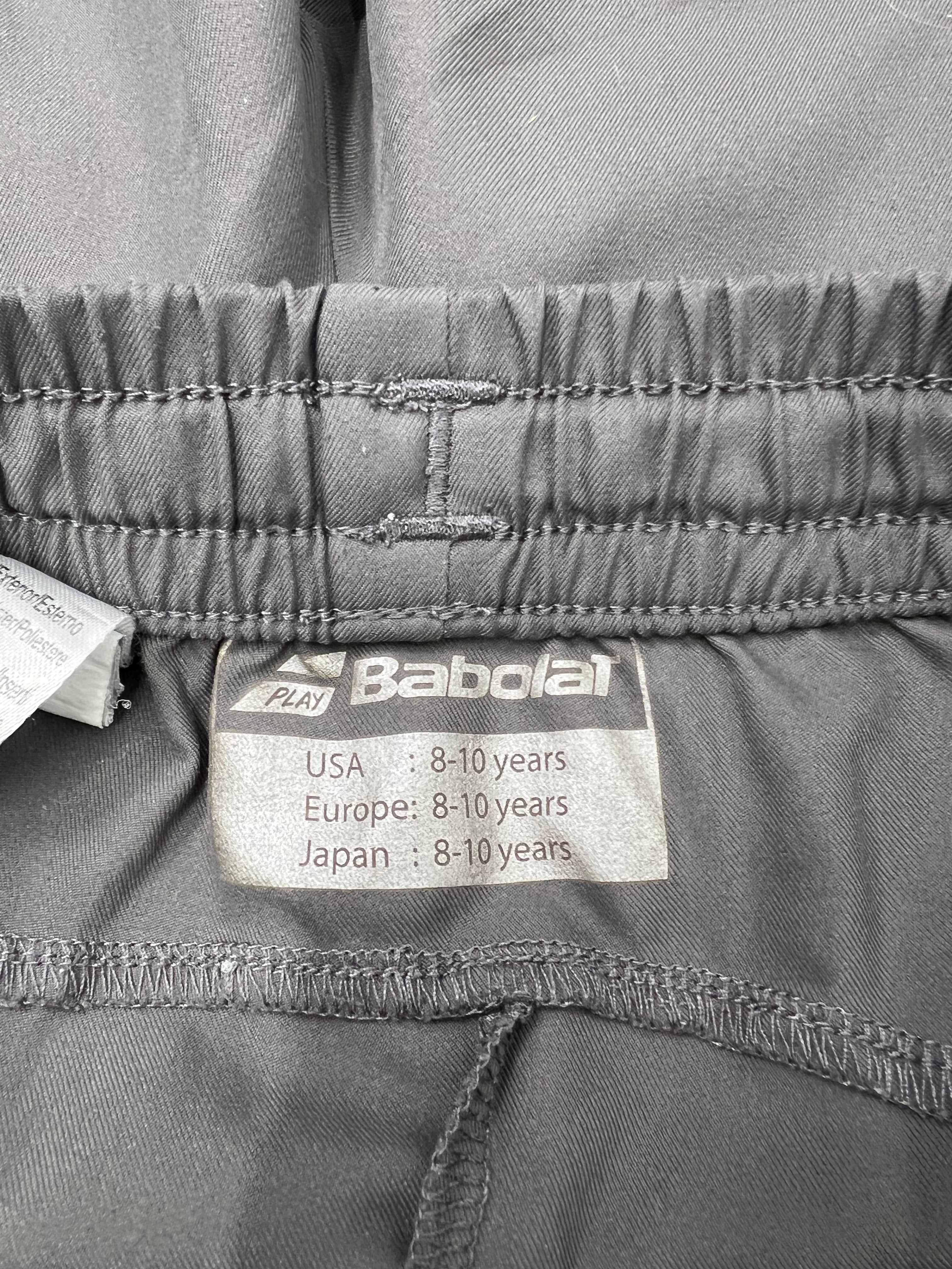 Close-up of Babolat size label inside grey kids training shorts