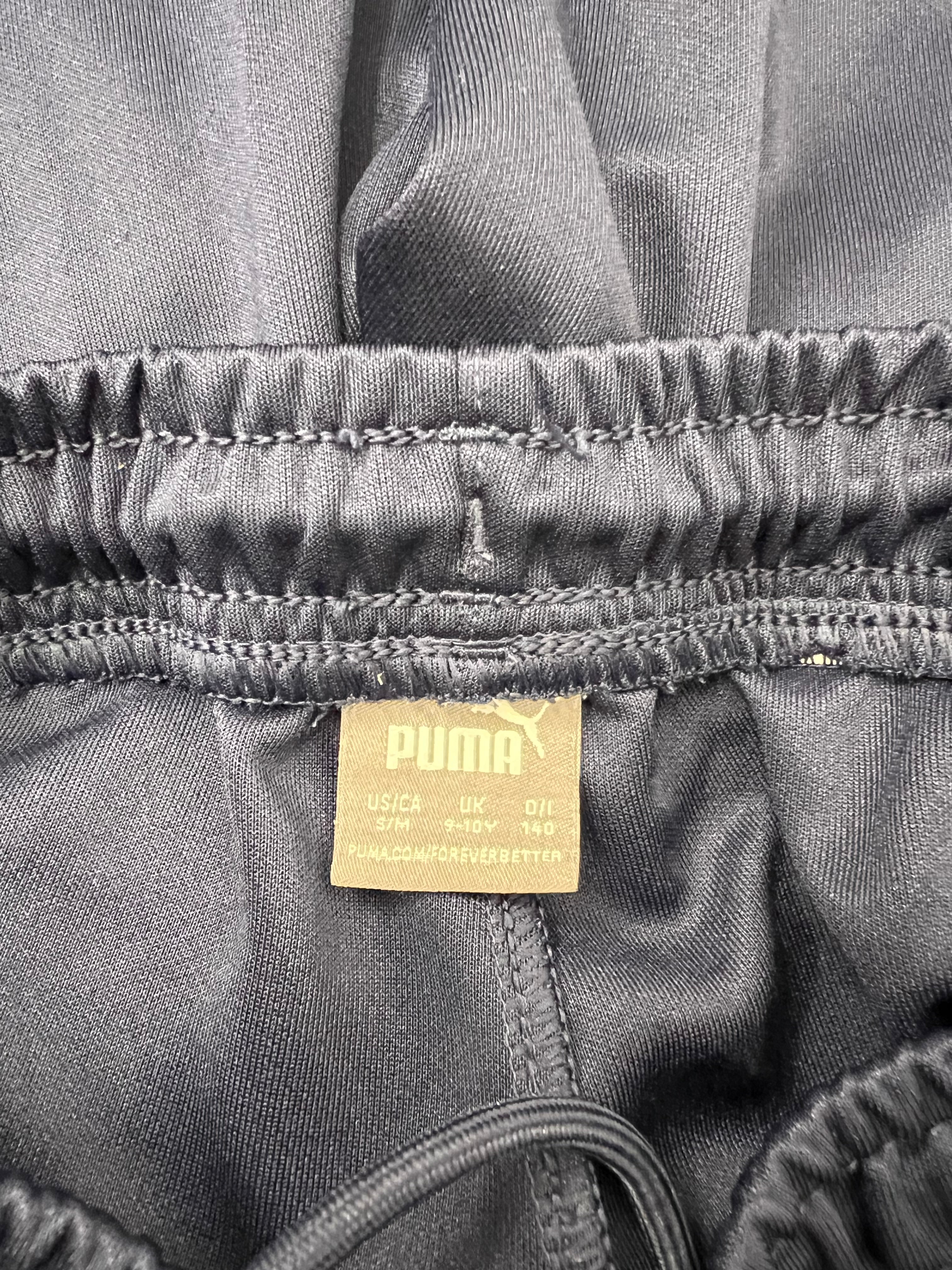 Close-up of Puma label inside navy blue tracksuit bottoms showing size 9-10 years