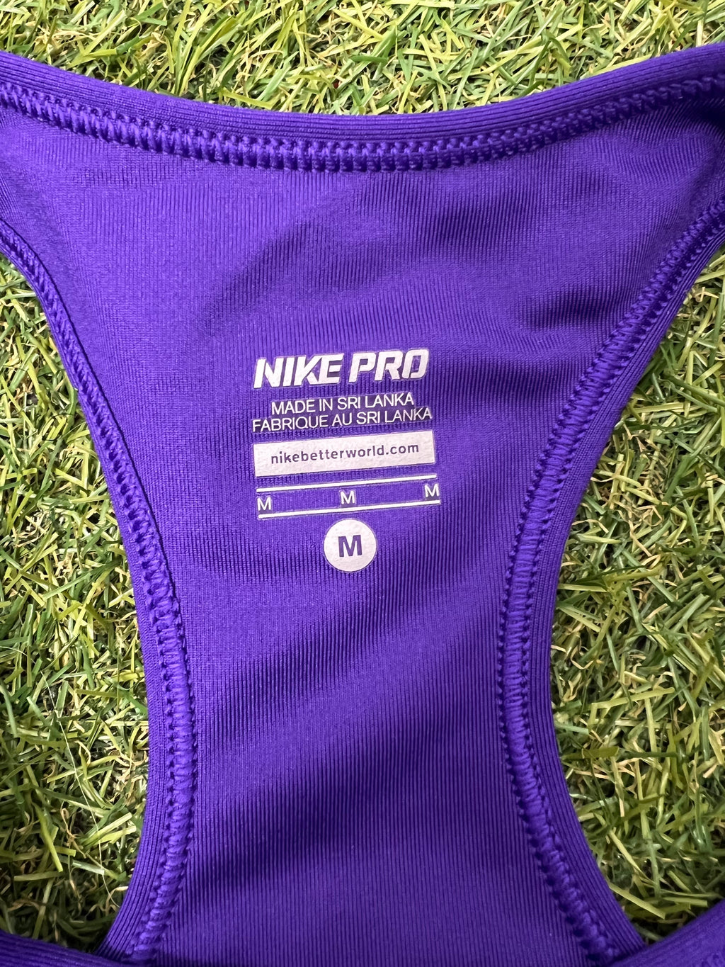 Close-up of sizing label and Nike Pro logo printed inside purple sports bra