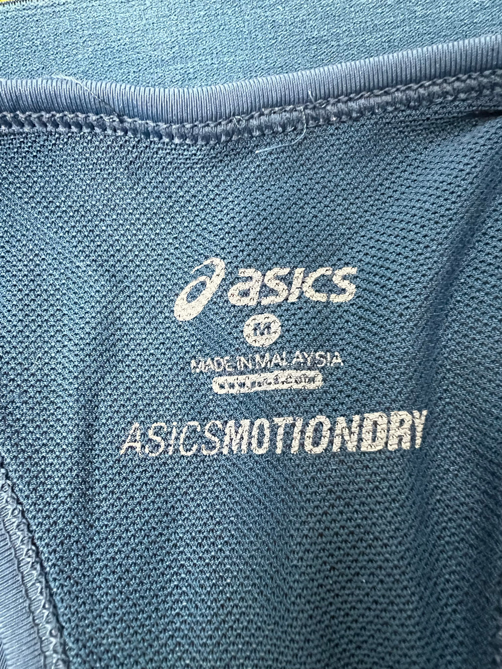 Close-up of interior Asics MotionDry label and mesh fabric of sports bra