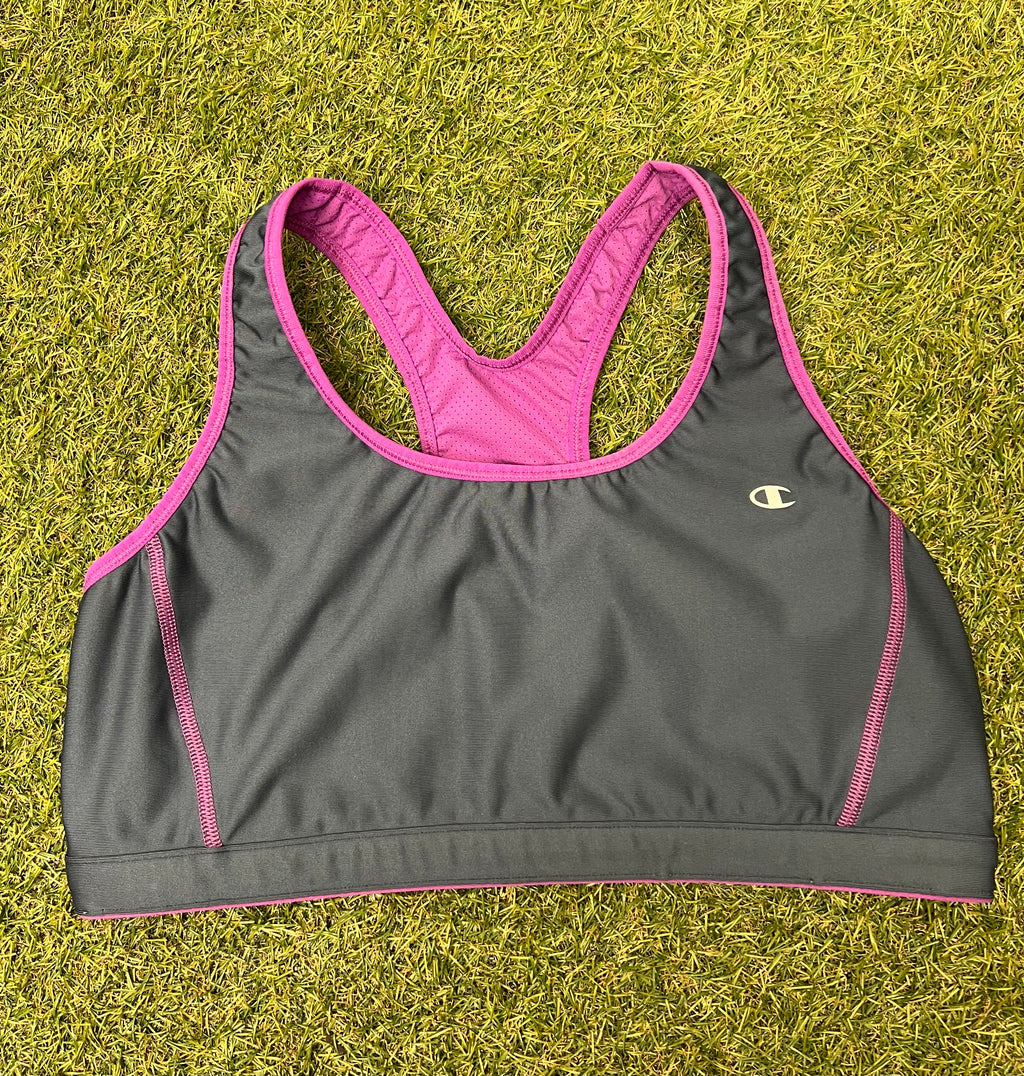 Front view of Champion sports bra top in grey with violet trim on grass