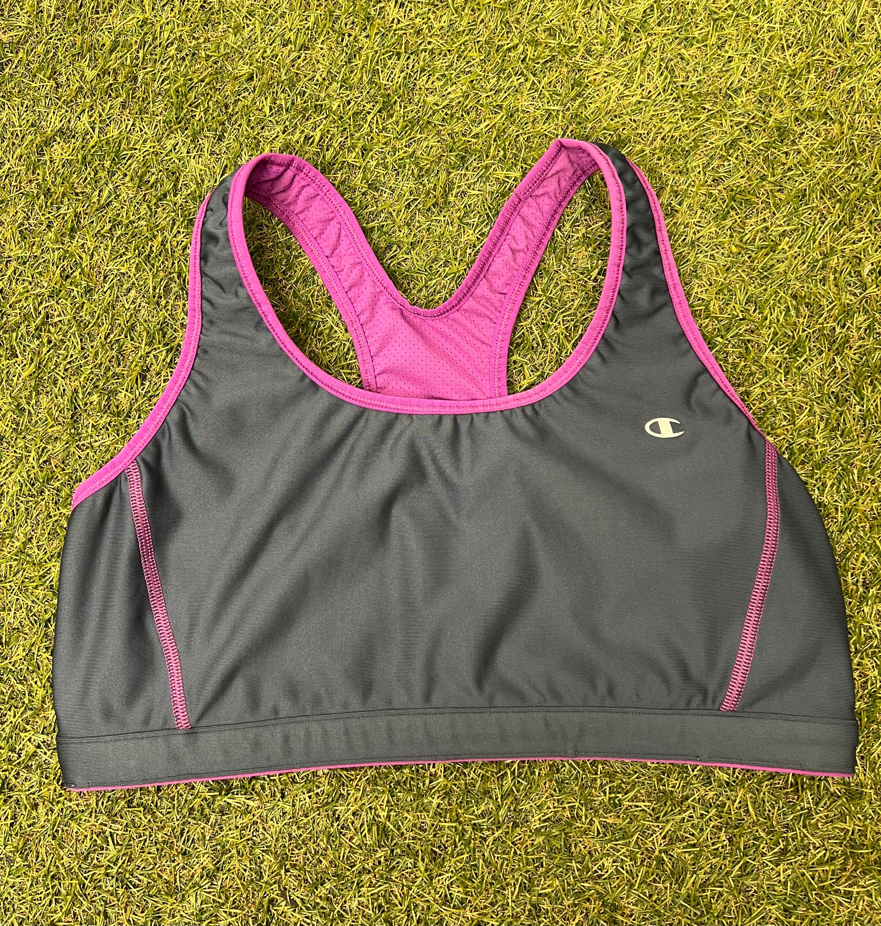Front view of Champion sports bra top in grey with violet trim on grass