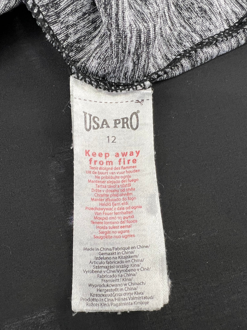 Close-up of USA Pro clothing label inside grey marl sports vest showing size 12 and care instructions
