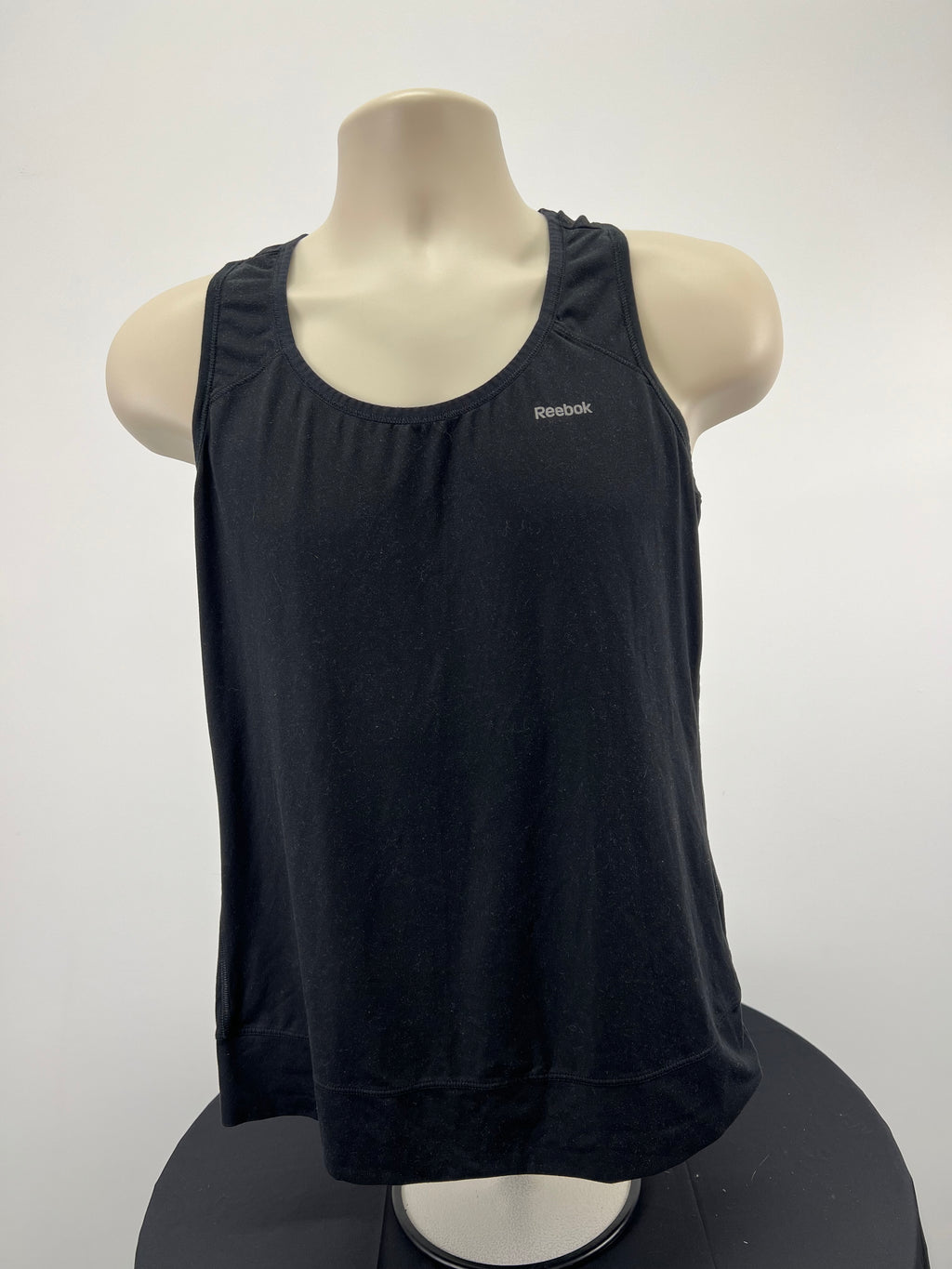 Front view of Reebok black sports vest on mannequin
