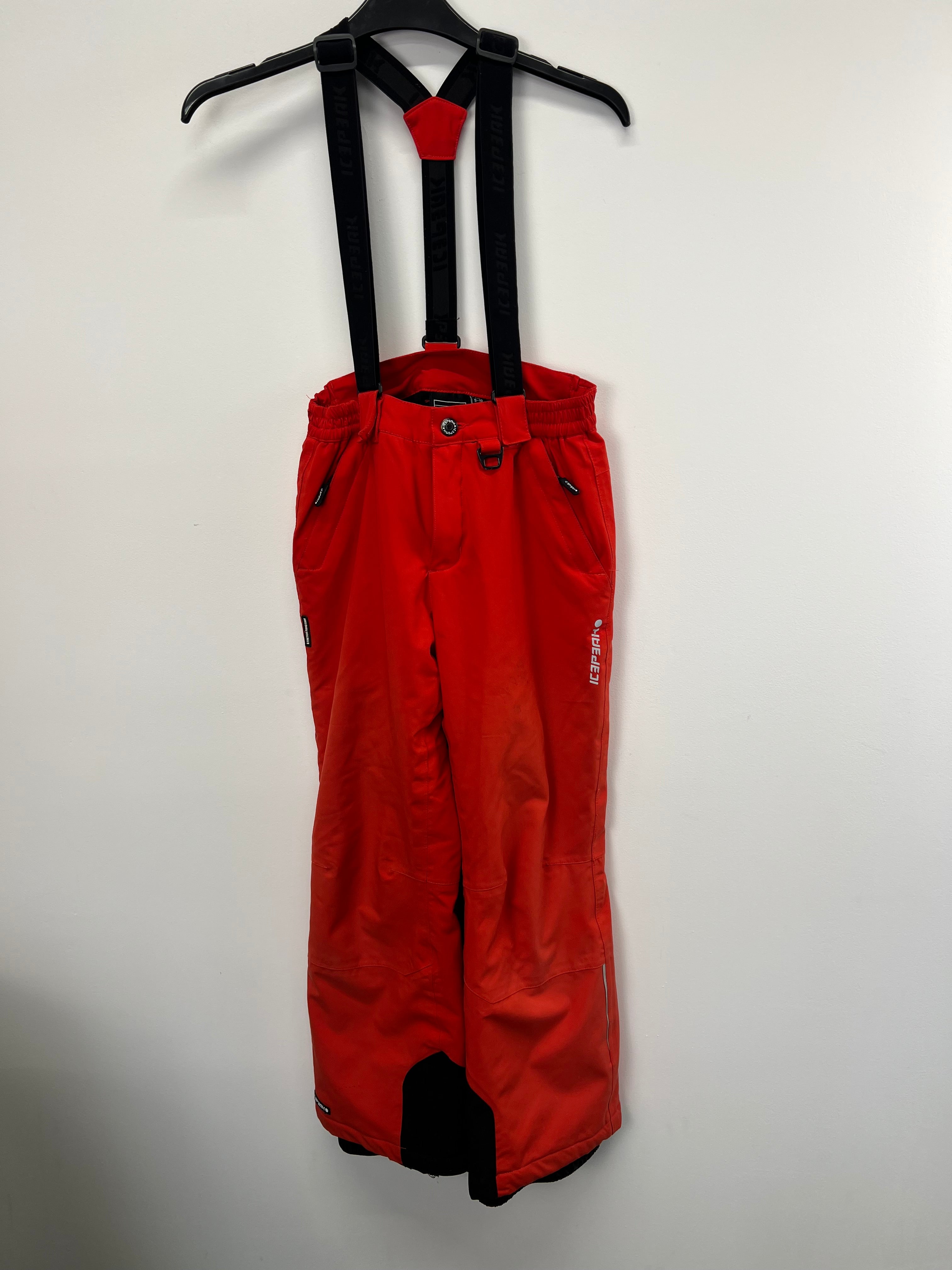 Front view of red Icepeak kids skiing trousers with black detachable braces on hanger