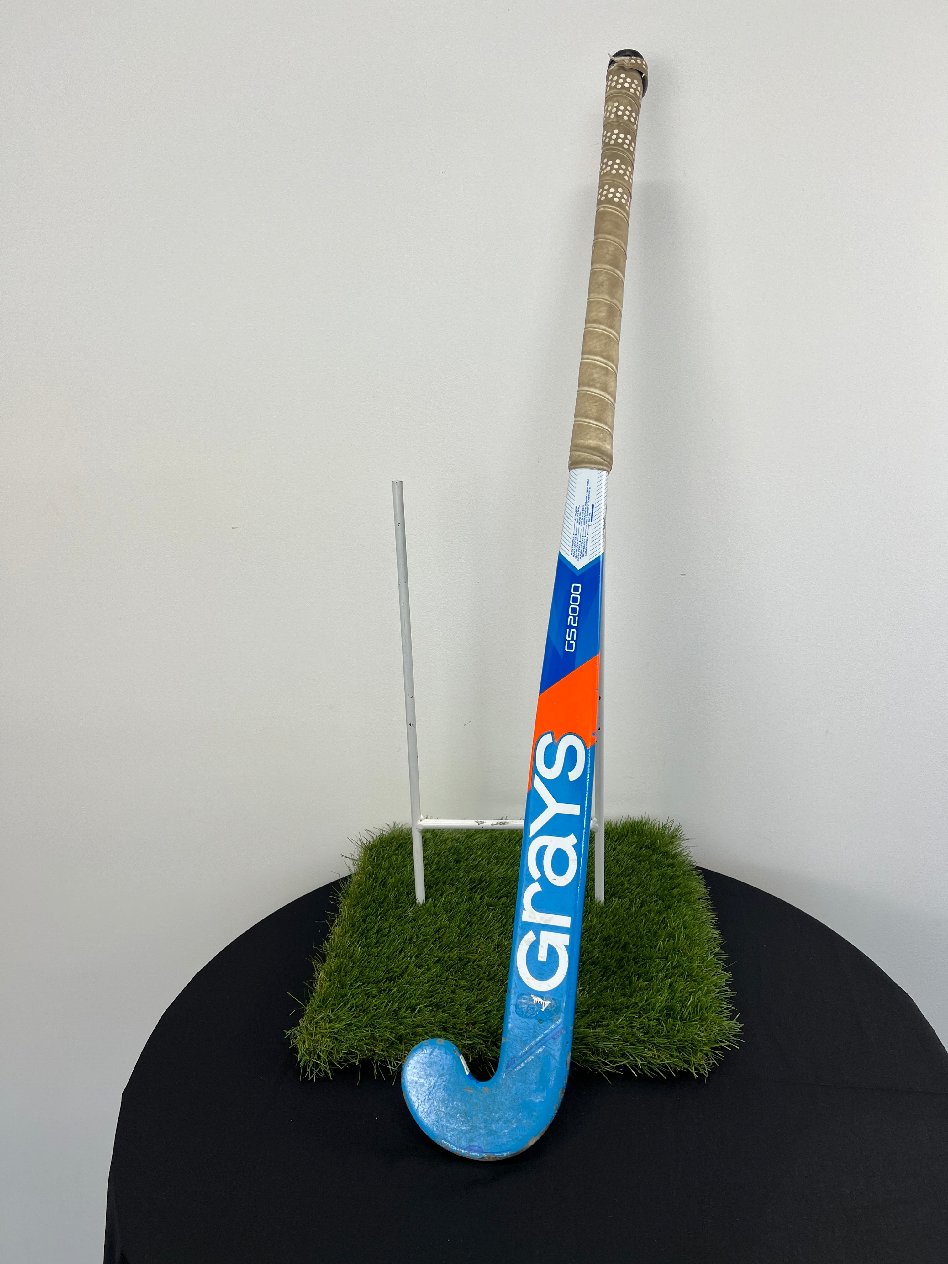 Side view of Grays hockey stick showing blue and orange design with beige grip