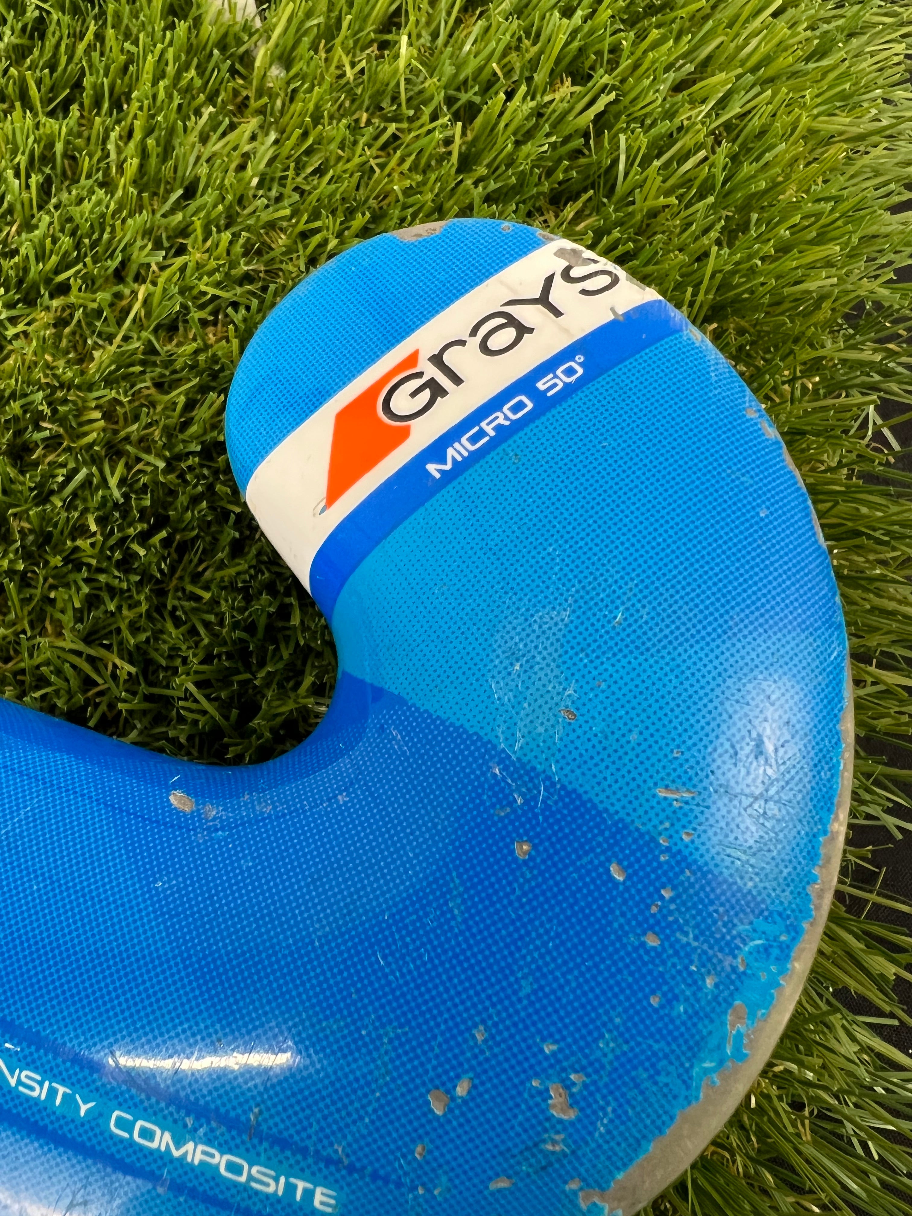 Detailed view of Grays Micro 50 branding on blue stick head with scuff marks