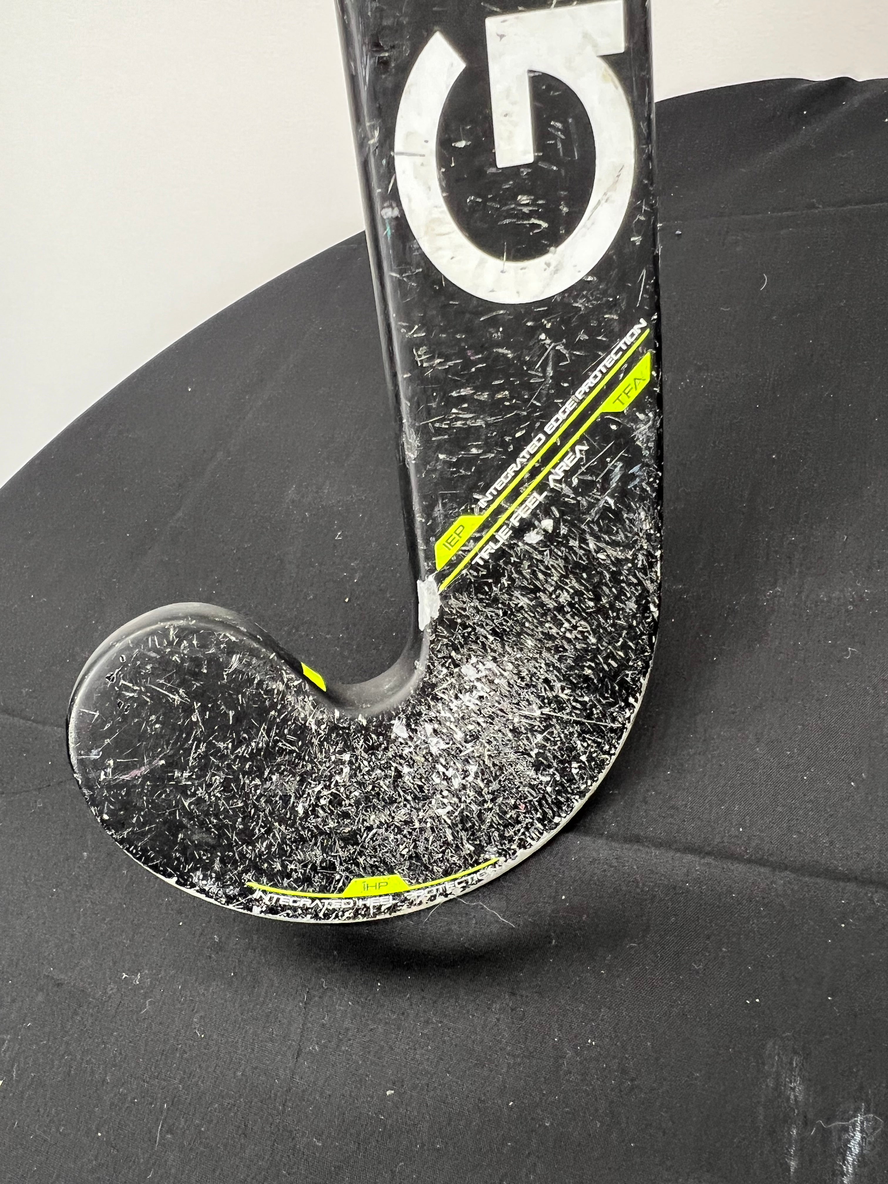 Close-up of worn toe and lower stick of Grays GS3000 Dynabow Micro 50 hockey stick with visible scratches