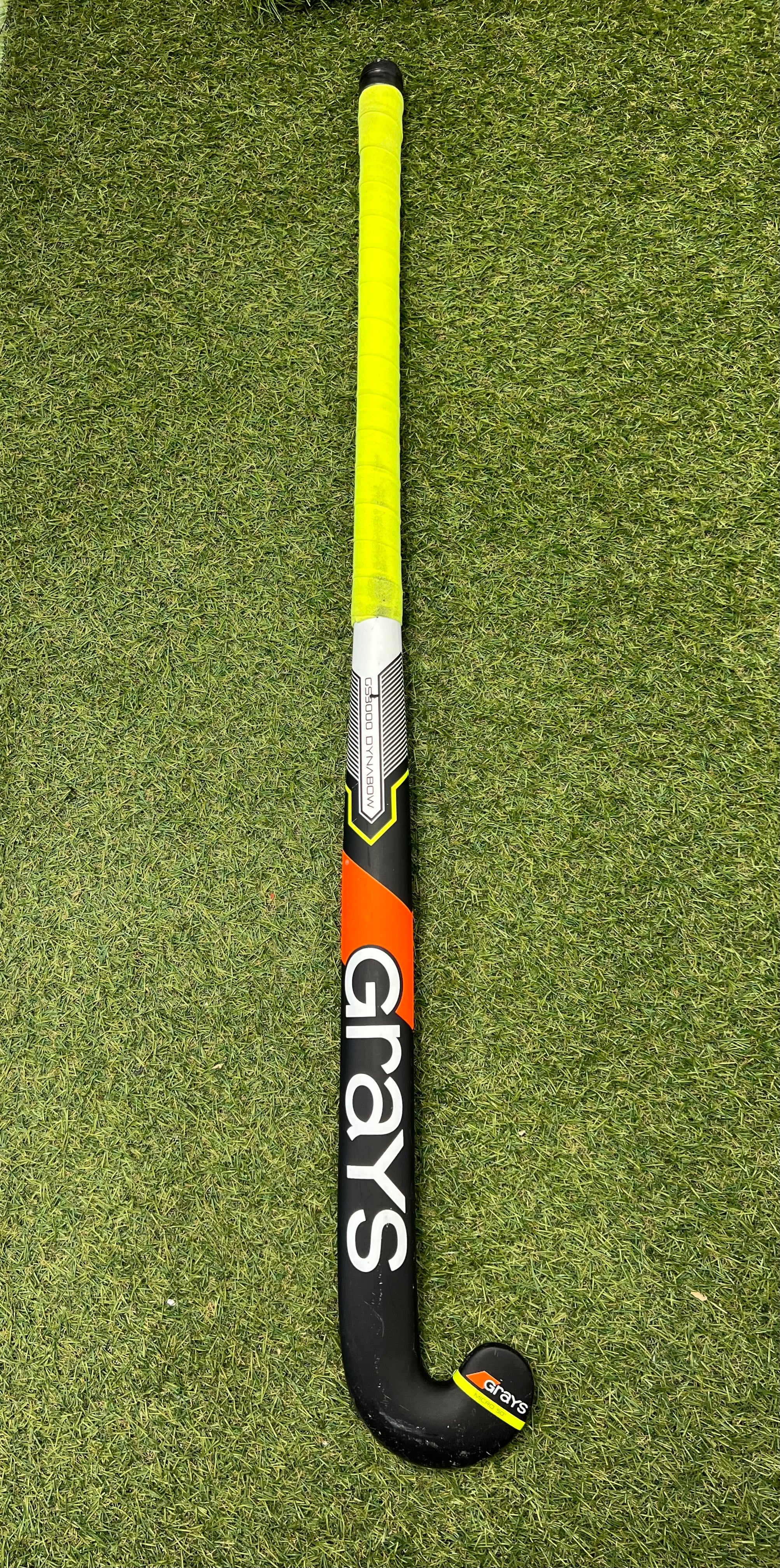 Grays GS3000 Dynabow Micro 50 37 inch hockey stick showing full top view with yellow grip on grass