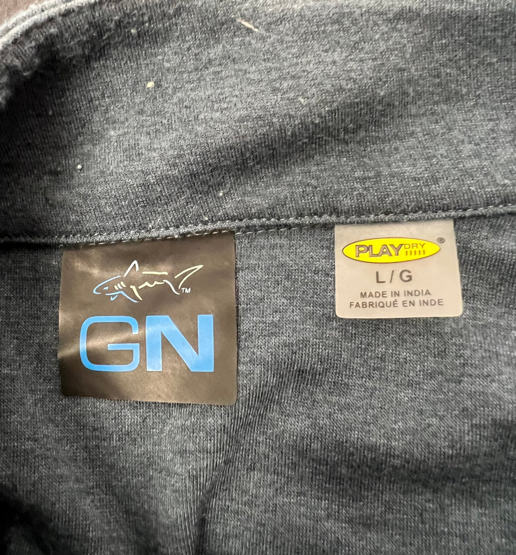 Close-up of Greg Norman jumper tag showing size L and PLAYDRY fabric feature