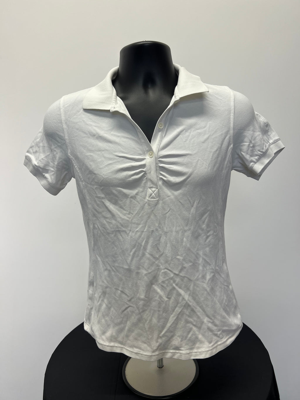 Front view of Women’s Galvin Green white polo shirt on display bust mannequin