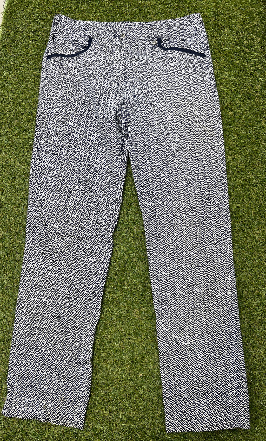 Women’s Golfino patterned golf trousers with navy and white zigzag design, laid flat on grass