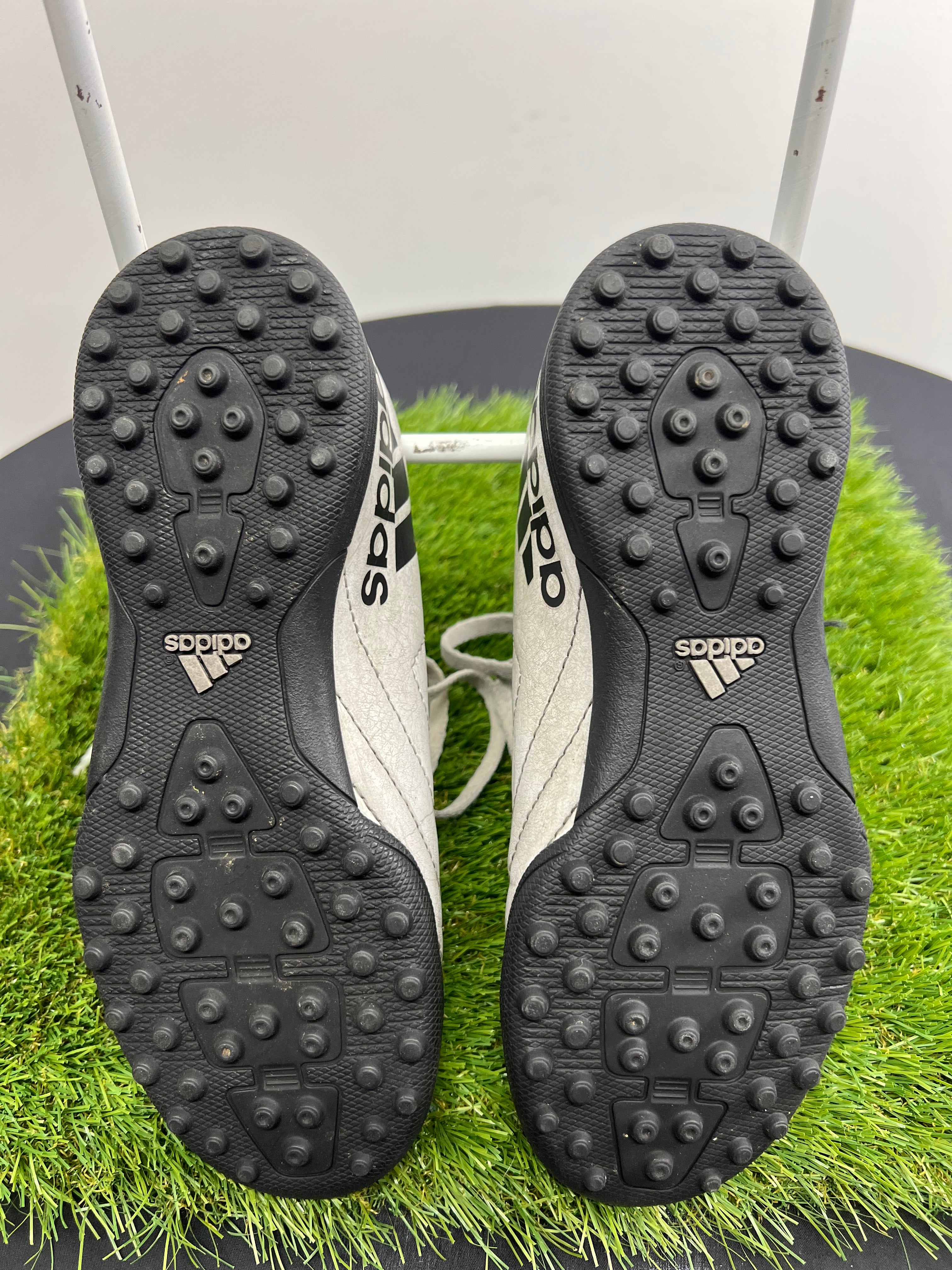 Underside view showing black rubber sole with multiple small studs on adidas kids football boots