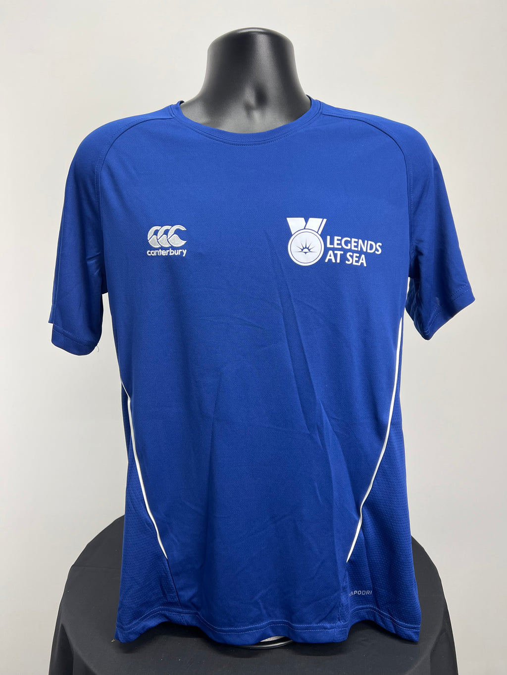 Front view of Canterbury men’s royal blue Team Dry Tee with Legends At Sea logo and white piping details